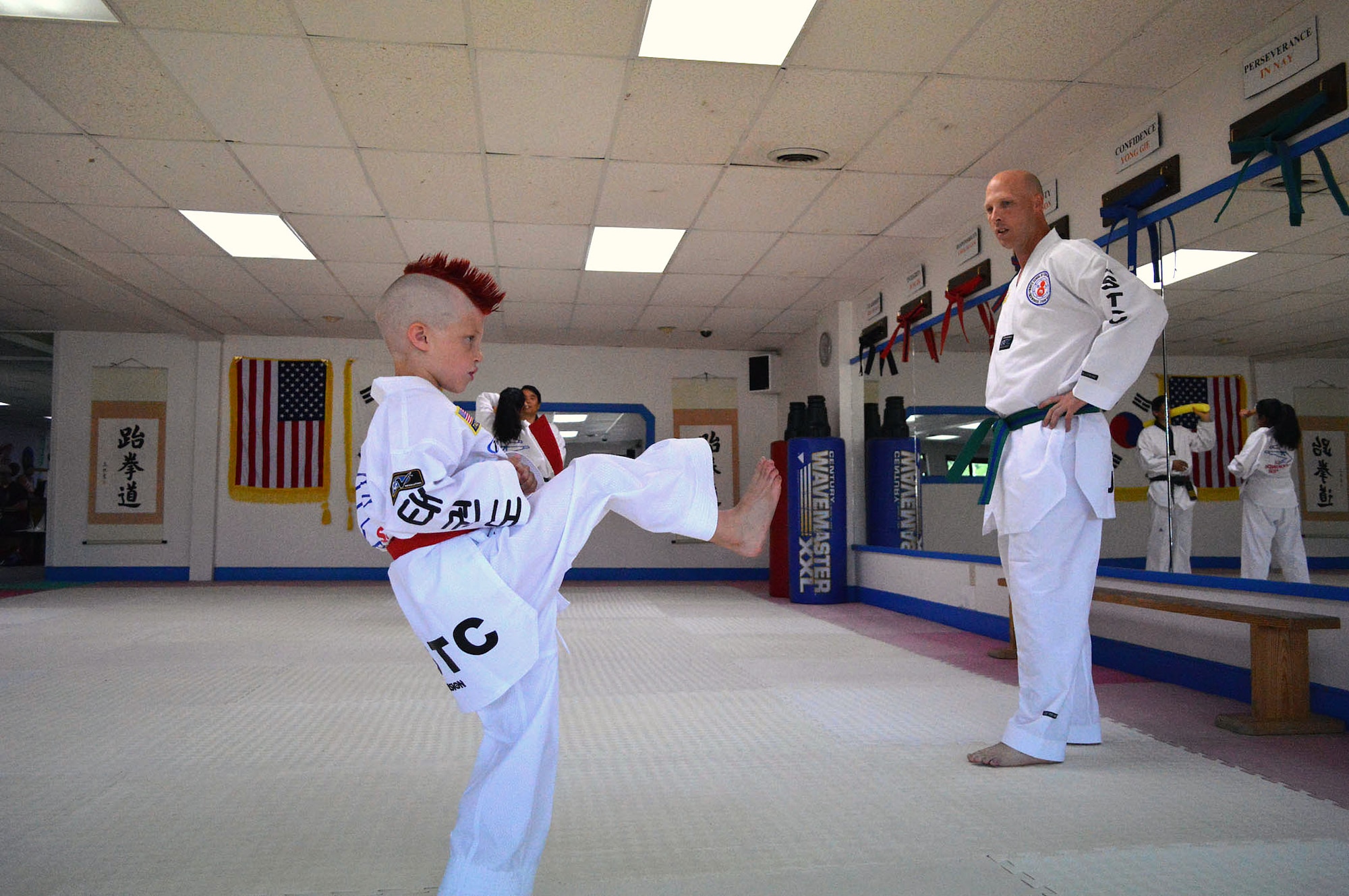 Kelan Wall, 7, practices his taekwondo creative forms at the U.S. Taekwondo Center in Spring Lake, North Carolina in preparation for the 6th annual U.S. Open Taekwondo Hanmadang competition in Colorado Springs, Colorado, while his father, Master Sgt. Stephen Wall, 43rd Logistics Readiness Squadron, watches and critiques his performance. (U.S. Air Force photo/Marvin Krause)