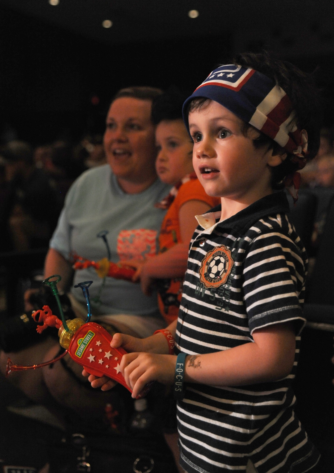 The son of Staff Sgt. Jonathan McMillan, 81st Diagnostic and Therapeutics Squadron, watches as Sesame Street characters arrive on stage during the Sesame Street USO Experience for Military Families show Sept. 19, 2014, at the Welch Theater, Keesler Air Force Base, Miss.  The 45-minute family-oriented event hosted by the 81st Force Support Squadron stars a character named Katie who is a military child.  With the help of her Sesame pals, Katie learns to deal with her fears and excitement about relocating.  The show emphasizes the importance of adjusting to change and the power of friendship. (U.S. Air Force photo by Kemberly Groue)