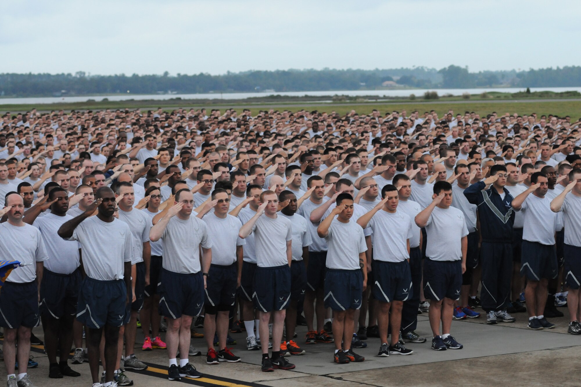 Keesler Airmen render a salute as the National Anthem is sung prior to the start of a 5K run on the flight line Sept. 19, 2014.  The run was the kickoff event for a day full of activities supporting Wingman Day.  (U.S. Air Force photo by Kemberly Groue)