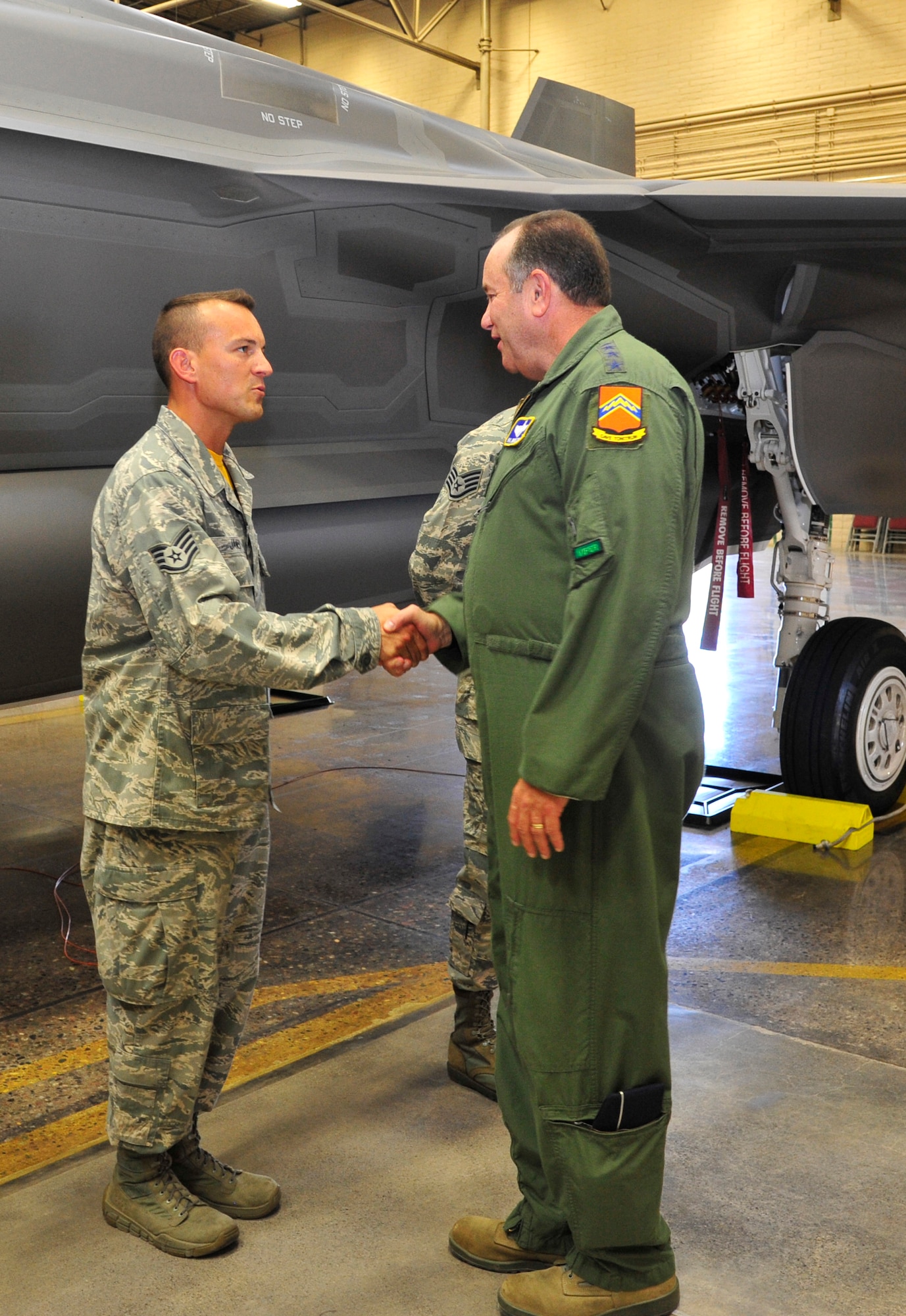 Staff Sgt. Robert James, 61st Aircraft Maintenance Unit dedicated crew chief, greets Breedlove in the F-35 Lightning II joint strike fighter academic training facility at Luke where James briefed the general on the Luke F-35 program. (U.S. Air Force photo/Senior Airman Grace Lee)