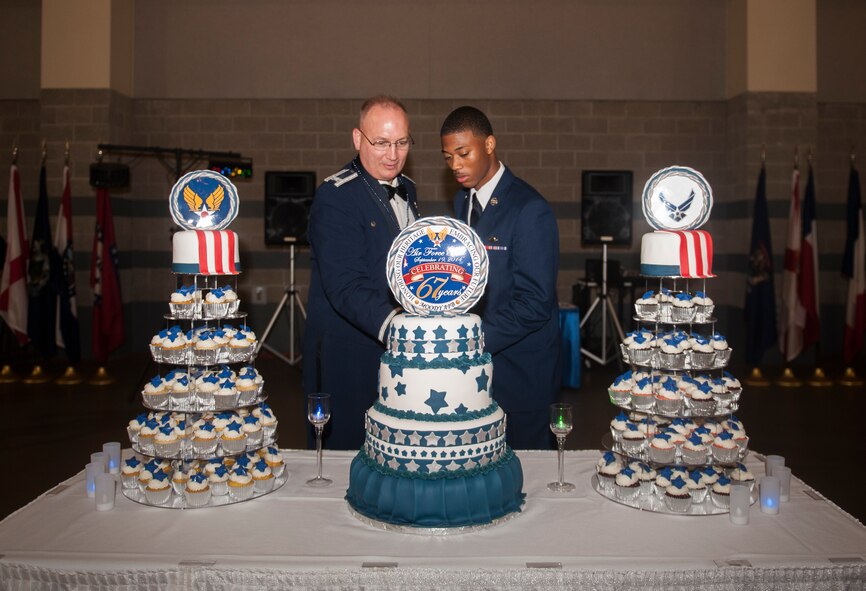 U.S. Air Force Col. Jeffrey Decker, 23d Maintenance Group commander, and Airman Raynard Billy, 23d Logistics Readiness Squadron, cut the first slice of cake at the Air Force Ball Sept. 19, 2014, in Valdosta, Ga. It is Air Force tradition for the most senior and junior ranked Airmen to cut the cake first. (U.S. Air Force photo by Senior Airman Olivia Bumpers/Released)