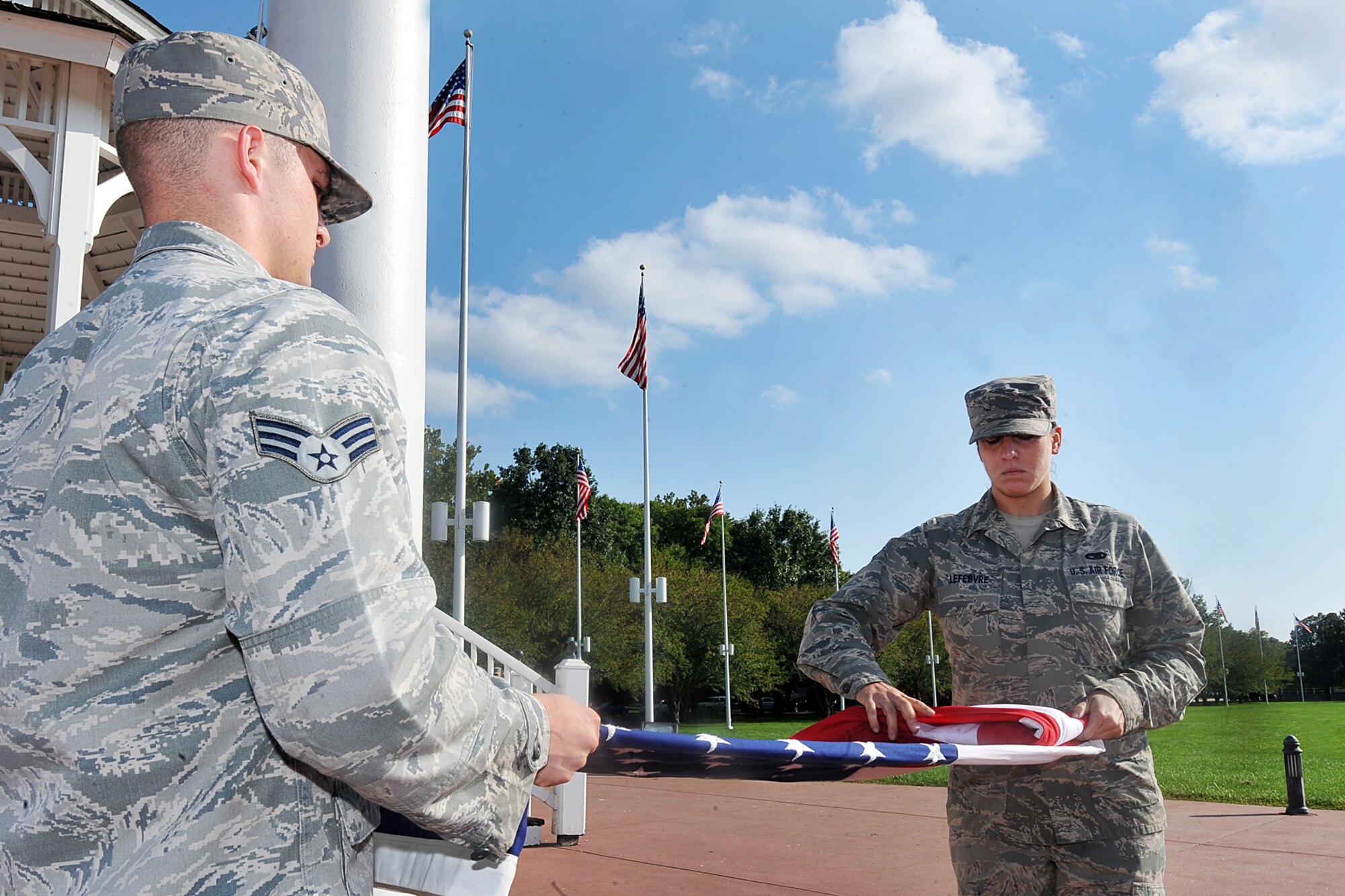 U.S. Air Force Senior Airmen Kameron Carver, 55th Maintenance Squadron, holds the fold while U.S. Air Force Senior Airmen Tawny Lefebvre, 55th Maintenance Squadron, folds the flag during the U.S. Air Force Birthday retreat ceremony on the parade grounds Sept. 18. Today's Air Force is the world's preeminent air, space and cyberspace force with an ability to rapidly adapt to uncertainty, ensuring future success.  (U.S. Air Force Photo by Charles Haymond)
