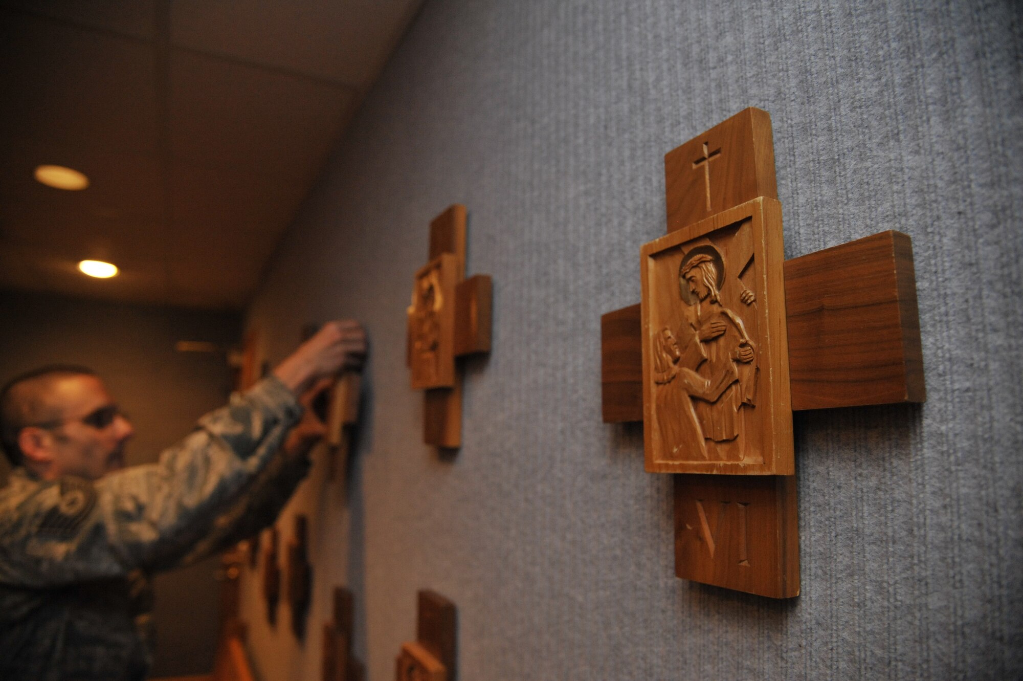 U.S. Air Force Tech. Sgt. Lukas Bartels, 509th Bomb Wing chaplain assistant, puts Stations of the Cross on chapel walls at Whiteman Air Force Base, Mo., Sept. 3, 2014. Chaplain assistants are trained in crisis intervention which entails dealing with thoughts on suicide, domestic violence and sexual assault.  Situations requiring immediate attention can be dealt with by either the chaplain or assistant. (U.S. Air Force photo by Airman 1st Class Keenan Berry/Released)