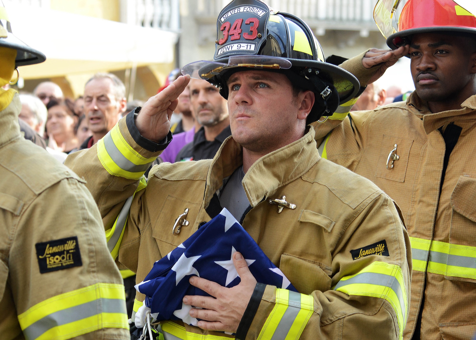 Staff Sgt. Zach Dyas, 31st Civil Engineer Squadron fire and emergency services crew chief, holds the American flag during a 9/11 remembrance ceremony at the 13th Annual Italian-American Friendship Festival, Sept. 20, 2014, in Sacile, Italy. Members from the 31st CES and Italian firefighters paid tribute to the lives lost on 9/11. (U.S. Air Force photo/Airman 1st Class Deana Heitzman)