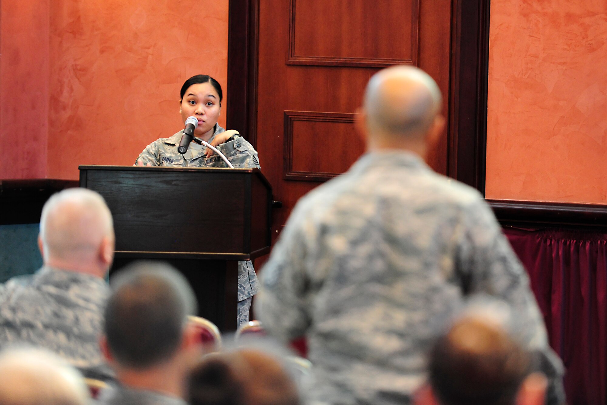 Tech. Sgt. Grace Barce, 31st Force Support Squadron force management NCO in charge, speaks to approximately 100 Airmen and their spouses during a town hall, Sept. 22, 2014, at Aviano Air Base, Italy. Briefers spoke about and fielded questions regarding a variety of recent changes. The topics discussed included Weighted Airmen Promotion System, promotion eligibility cutoff dates and testing windows, tuition assistance, timelines for TA applications and home fuels allowances, benefits, billing and improvements. (U.S. Air Force photo/Airman 1st Class Ryan Conroy) 
