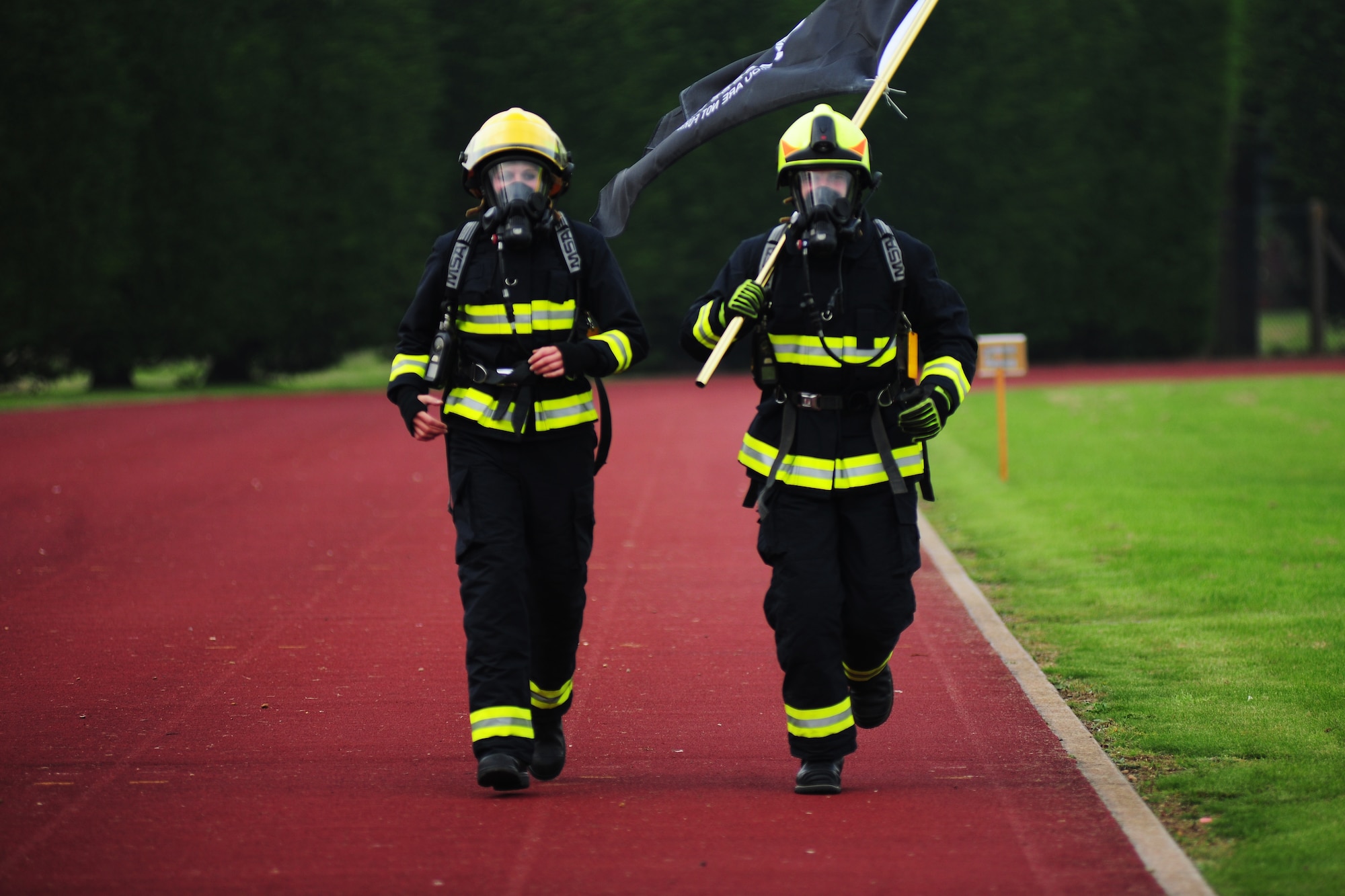 Kerry Hyde, 423rd Civil Engineer Squadron firefighter and native of St. Neots, United Kingdom, left, and Tom Hodgetts, 423rd CES firefighter and native of Lincolnshire, right, jog on the track at RAF Alconbury during a POW/MIA Recognition Run, Sept. 19, 2014. The most recent U.S. prisoner of war to be accounted for was U.S. Army Private 1st Class Richard Bean, who was lost June 15, 1944, and will be buried with full military honors. (U.S. Air Force photo by Staff Sgt. Jarad A. Denton/Released)