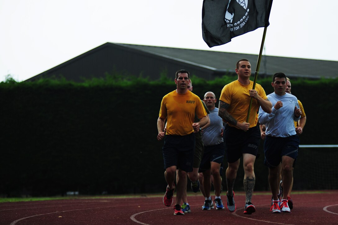 Service members from the U.S. Africa Command Joint Analysis Center at RAF Molesworth run in formation during a POW/MIA Recognition Run at RAF Alconbury, United Kingdom, Sept. 19, 2014. Since World War II, 83,189 U.S. Service members have yet to be accounted for or returned home. (U.S. Air Force photo by Staff Sgt. Jarad A. Denton/Released)