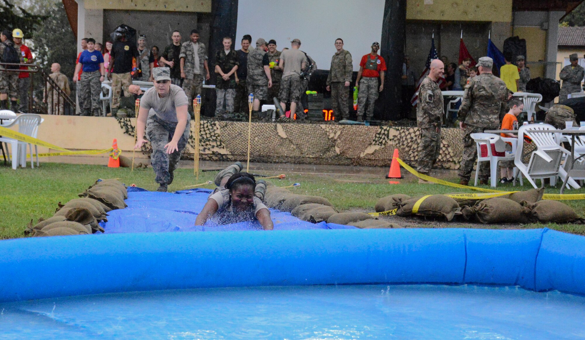Airman 1st Class Joi L. Parker, 39th Communications Squadron, cyber transport technician, slides on the water slide at a combat dining out at Arkadas Park Sept. 19, 2014, Incirlik Air Base, Turkey. The combat dining-out also had a combat obstacle course and water balloon fight. (U.S. Air Force photo by Airman Cory W. Bush/Released)