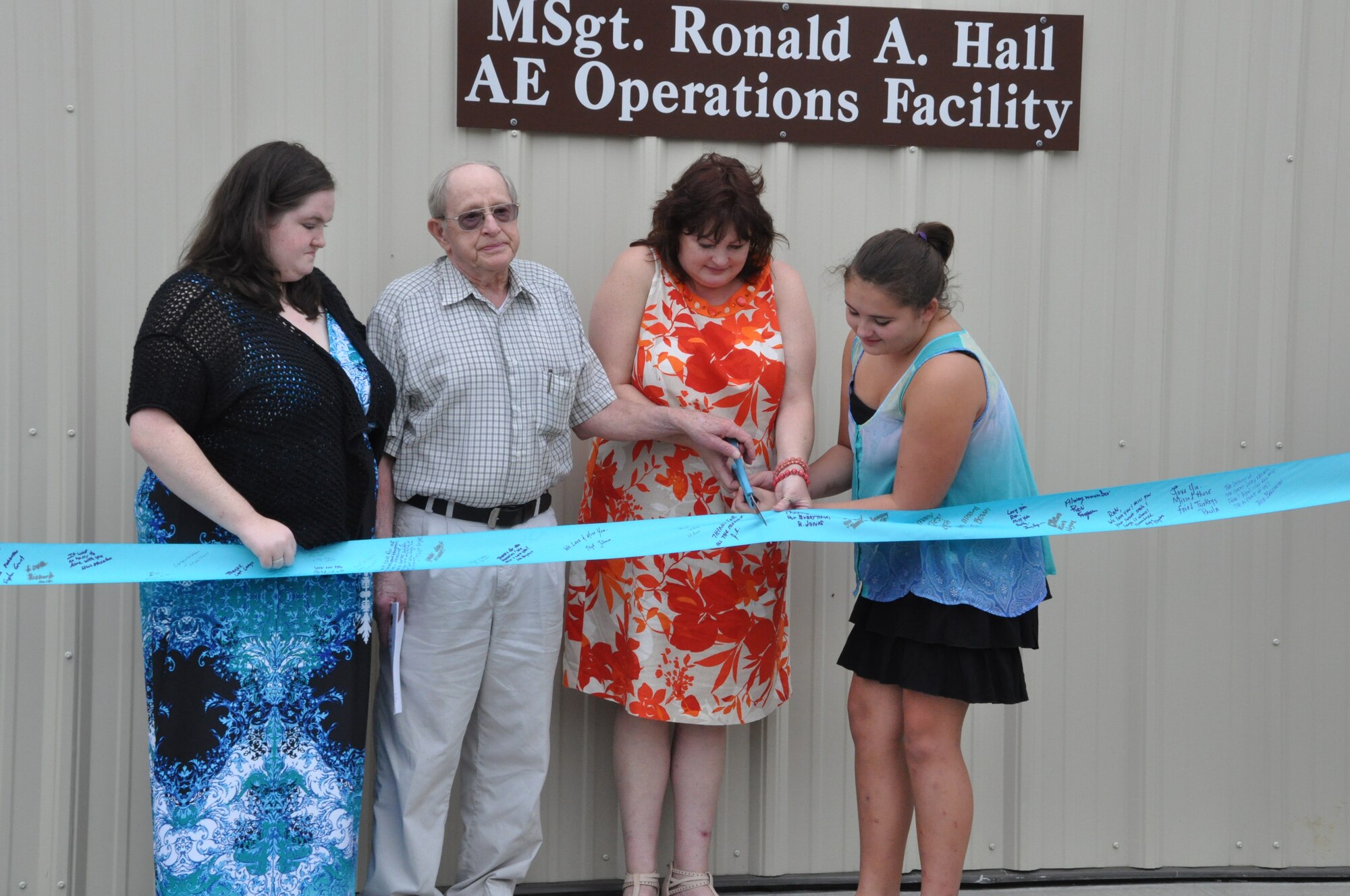 Rosemary Green-Hall, wife of Master Sergeant Ron Hall, daughters, Emily and Sarah, and father-in-law Ronald H. Hall prepare to cut the ribbon for the Master Sergeant Ronald A. Hall Aeromedical Evacuation Operations Facility during a dedication ceremony Sept. 21, 2014 at Joint Base Charleston, S.C. The building was named after Master Sgt. Ronald Hall, who spent 24 of his 28 years in the Air Force as a member of the 315th Aeromedical Evacuation Squadron. After years of dedicated service to the military, Hall passed away in May 2011. (U.S. Air Force photo by Capt. Michaela Judge)
