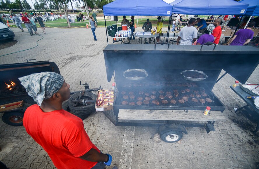 39th Air Base Wing Airmen enjoy hamburgers and hotdogs at a combat dining-out at Arkadas Park Sept. 19, 2014, Incirlik Air Base, Turkey. The dining-out also had a grog bowl which consisted of a different ingredient that each squadron on base was required to provide. (U.S. Air Force photo by Airman Cory W. Bush/Released)