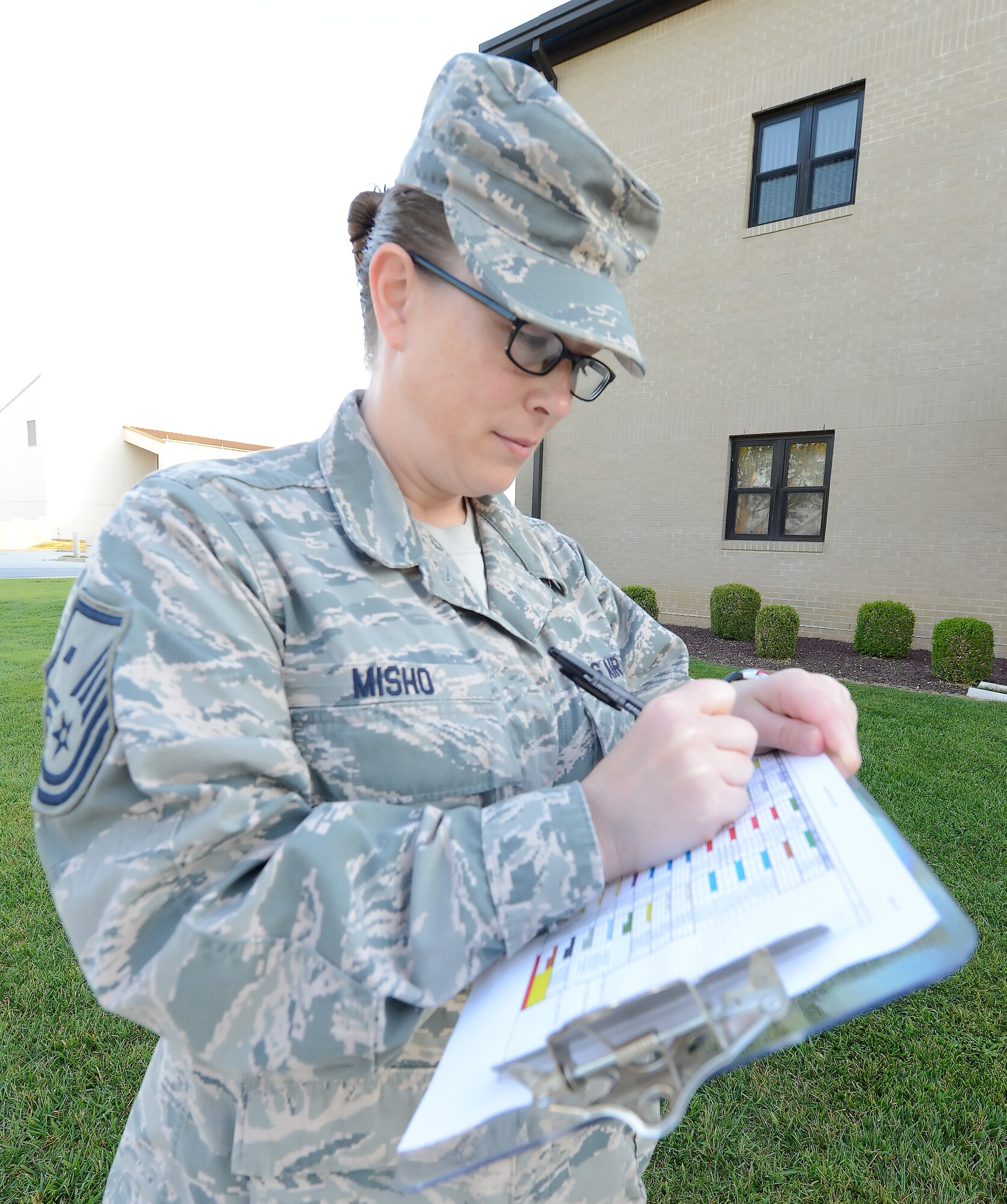 Master Sgt. Brea Misho, 436th Operations Support Squadron first sergeant, makes notes on the master list of participants in POW/MIA Remembrance Day activities Sept. 19, 2014, at Dover Air Force Base, Del. Misho checked in groups of four who stood vigil for 15 minutes at a time next to the base flag pole during the entire duty day. (U.S. Air Force photo/Greg L. Davis)