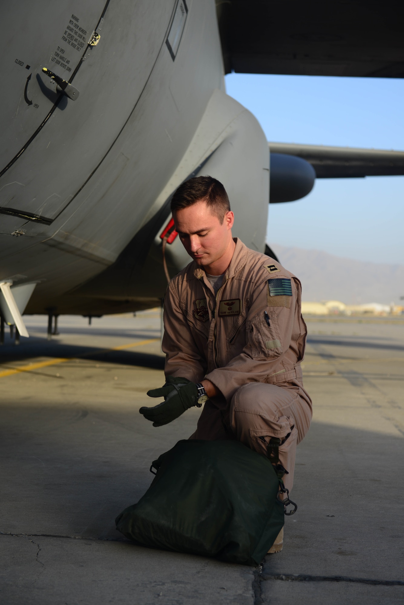 U.S. Air Force Capt. Frank Von Heiland, 41st Expeditionary Electronic Combat Squadron co-pilot, puts gloves on before EC-130H Compass Call aircraft walk through at Bagram Airfield, Afghanistan Sept. 12, 2014.  The 41 EECS provides premier counter-communications electronic attack capabilities.  The unit has flown 6,600 sorties and 38,000 hours in support of Operation Enduring Freedom.  Von Heiland is deployed from Davis-Monthan Air Force Base, Ariz. and a native of Anaheim, Calif. (U.S. Air Force photo by Staff Sgt. Evelyn Chavez/Released)  