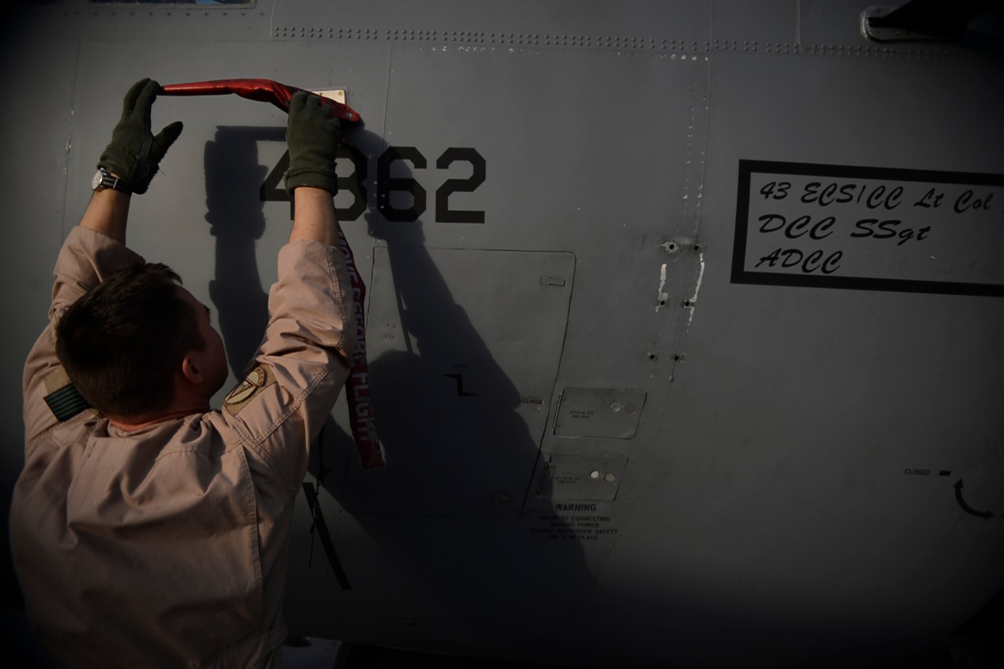 U.S. Air Force Capt. Frank Von Heiland, 41st Expeditionary Electronic Combat Squadron co-pilot, removes a pilot cover from an EC-130H Compass Call aircraft at Bagram Airfield, Afghanistan Sept. 12, 2014.  The 41 EECS provides premier counter-communications electronic attack capabilities. Von Heiland is deployed from Davis-Monthan Air Force Base, Ariz. and a native of Anaheim, Calif.  (U.S. Air Force photo by Staff Sgt. Evelyn Chavez/Released)