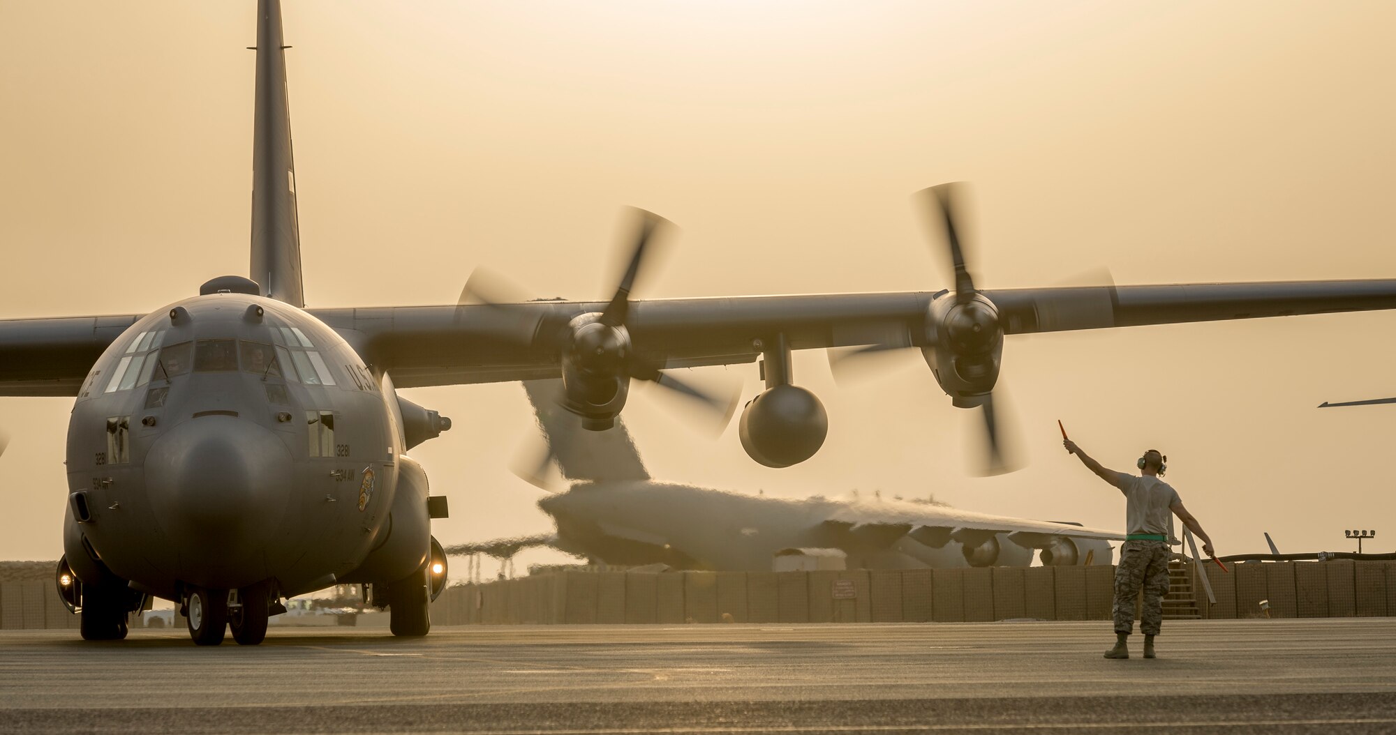 U.S. Air Force Senior Master Sgt. Kyle Klass, 386th Expeditionary Aircraft Maintenance Squadron, dayshift production superintendent, marshals a C-130H Hercules from the 934th Air Wing after it landed at its new home Sept. 12, 2014 at an undisclosed location in Southwest Asia. The crew will be stationed with the 386th Air Expeditionary Wing for the next four months and deployed from Minneapolis-St Paul Air Reserve Station, Minn. in support of Operation Enduring Freedom. (U.S. Air Force photo by Staff Sgt. Jeremy Bowcock)