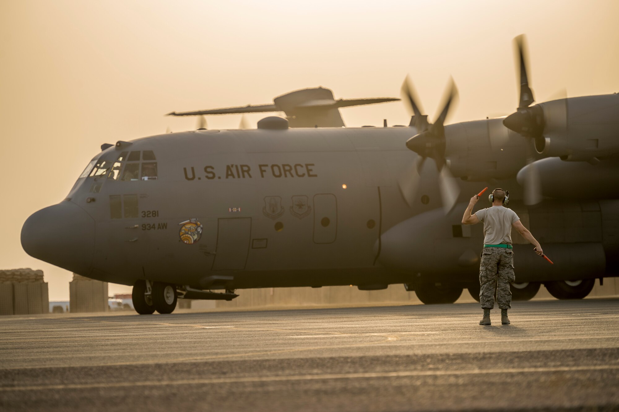 U.S. Air Force Senior Master Sgt. Kyle Klass, 386th Expeditionary Aircraft Maintenance Squadron, dayshift production superintendent, marshals a C-130H Hercules from the 934th Air Wing after it landed at its new home Sept. 12, 2014 at an undisclosed location in Southwest Asia. The crew will be stationed with the 386th Air Expeditionary Wing for the next four months and deployed from Minneapolis-St Paul Air Reserve Station, Minn. in support of Operation Enduring Freedom. (U.S. Air Force photo by Staff Sgt. Jeremy Bowcock)
