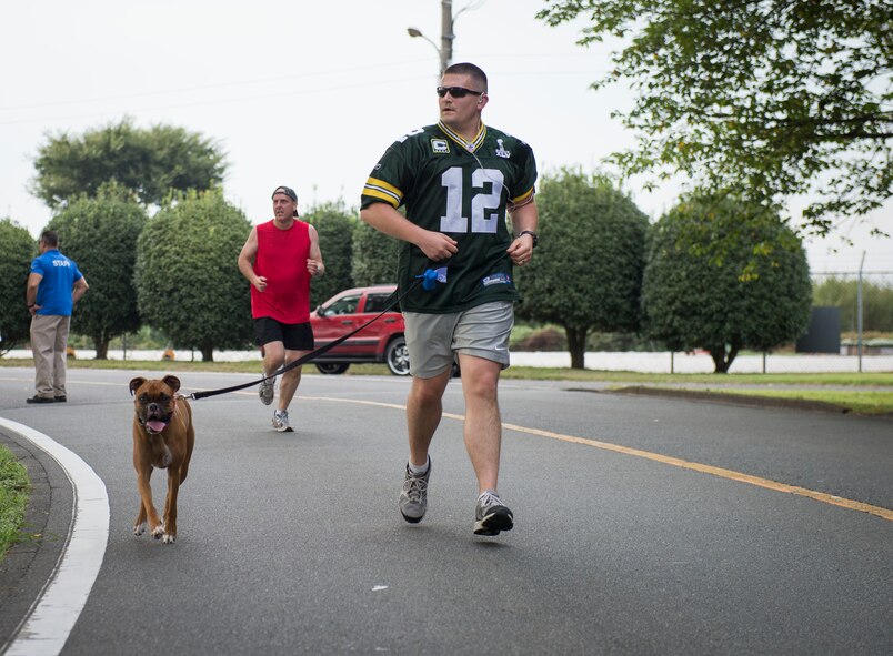 Capt. Ryon Migacz, 5th Air Force Misawa program manager, runs with his dog at Yokota Air Base, Japan, Sept. 19, 2014. There were over 100 participants at this wing fun run. (U.S. Air Force photo by Airman 1st Class Meagan Schutter/Released)