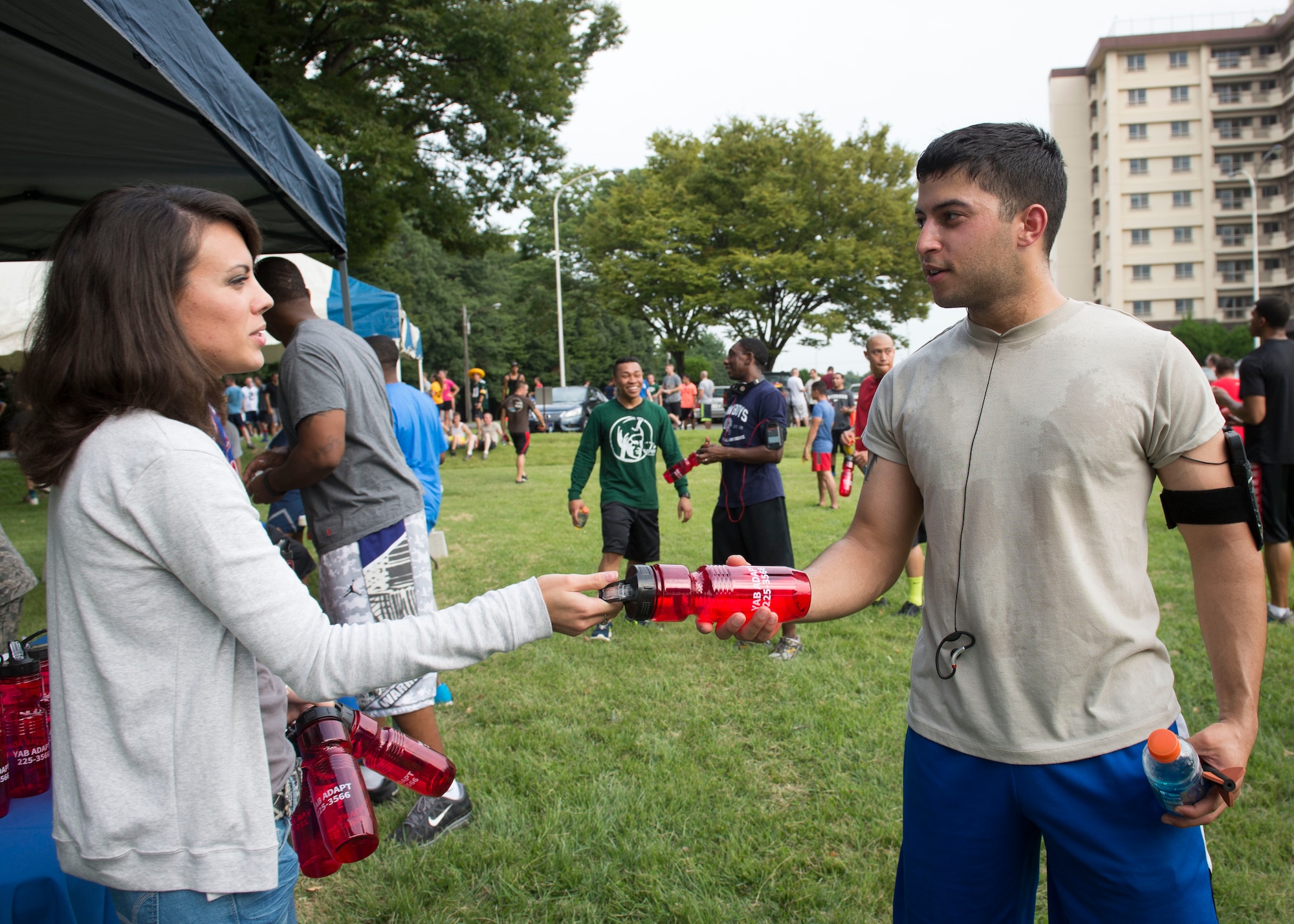 A representative from United Services Organization hands a water bottle to a participant after completing the 5k wing fun run at Yokota Air Base, Japan, Sept. 19, 2014. Booths featuring USO, University of Maryland University College, Sexual Assault Prevention Response and more, handed out prizes and information about their organization. (U.S. Air Force photo by Airman 1st Class Meagan Schutter/Released)