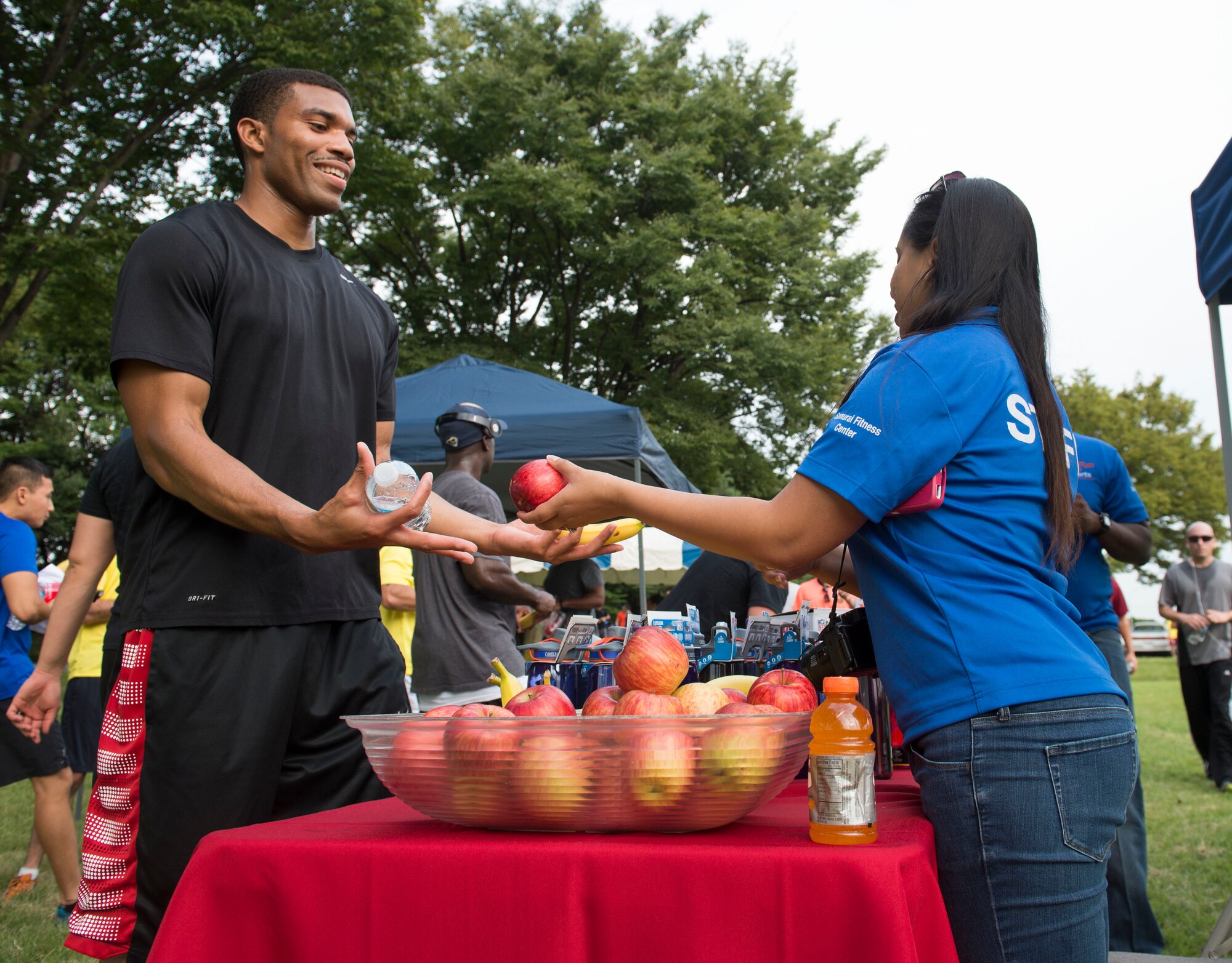 Senior Airman Michelle Jacobs, 374th Force Support Squadron fitness specialist hands out water and food to participants at Yokota Air Base, Japan, Sept. 19, 2014. The Turkey Trot will be the next wing fun run on the 22nd of November. (U.S. Air Force photo by Airman 1st Class Meagan Schutter/Released)