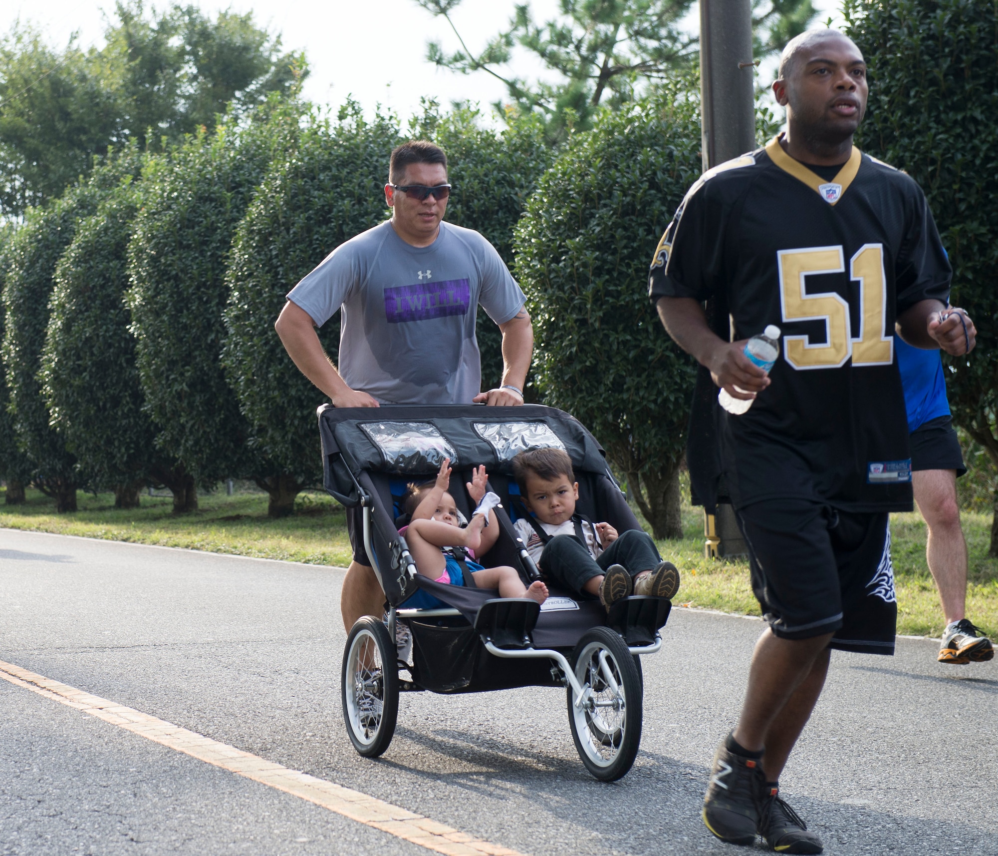 An Airman runs with his kids during the wing fun run at Yokota Air Base, Japan, Sept. 19, 2014.  Participants could run with their family and bring their pets along for the run. (U.S. Air Force photo by Airman 1st Class Meagan Schutter/Released))