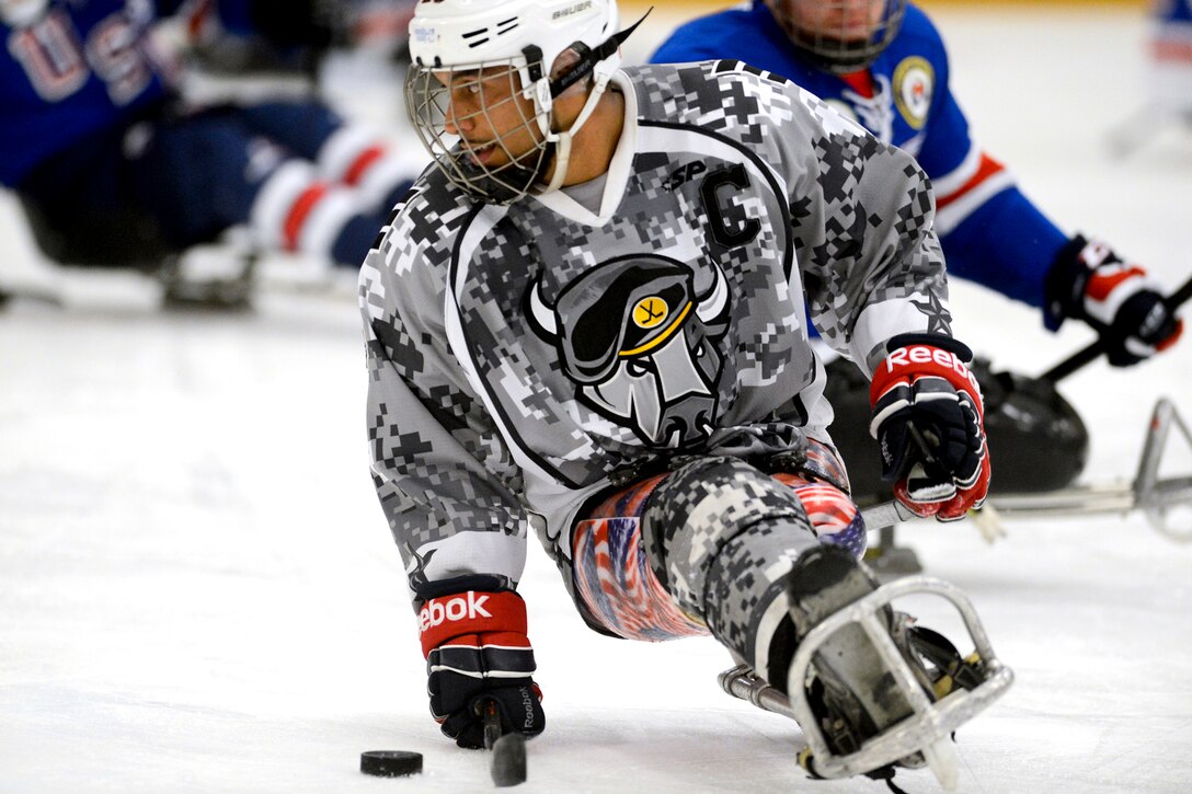 Army veteran Rico Roman handles a puck during a sled hockey game in Rockville, Md., Sept. 18, 2014. Roman was a member of the U.S. National Sled Hockey Team that won the gold medal at the 2014 Paralympics in Sochi, Russia.