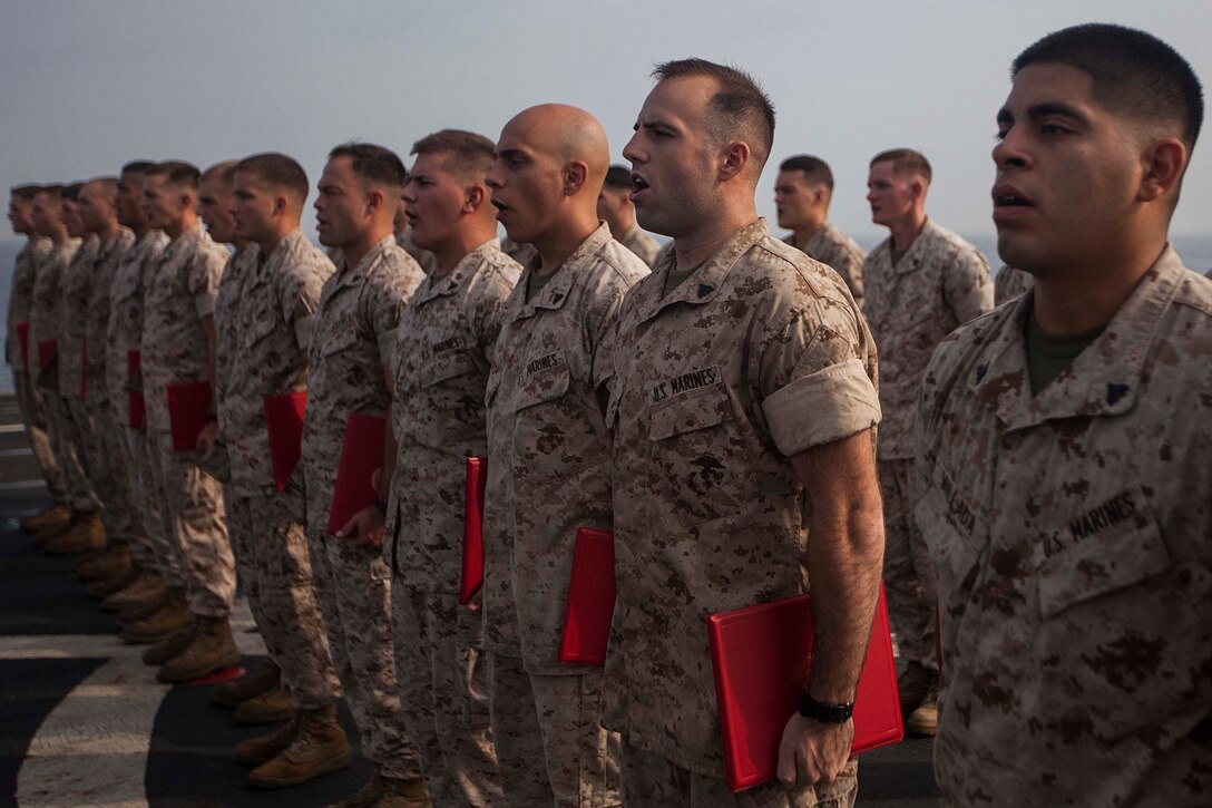 U.S. Marines sing the Marines’ Hymn during a corporals course graduation ceremony aboard the amphibious dock landing ship USS Gunston Hall (LSD 44). The 22nd MEU is deployed with the Bataan Amphibious Ready Group as a theater reserve and crisis response force throughout U.S. Central Command and the U.S. 5th Fleet area of responsibility. (U.S. Marine Corps photo by Sgt. Austin Hazard/Released)