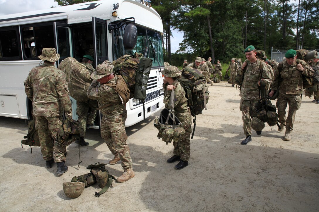 British soldiers of the 5, 6, and 7 Military Intelligence Battalions, 1 Intelligence Surveillance Reconnaissance Brigade, board buses to return to the barracks at the conclusion of Exercise Phoenix Odyssey on Sept. 17, 2014. The week-long field exercise, conducted alongside Marines of 2nd Intelligence Battalion, II Marine Expeditionary Force, provided scenario driven tests of their ability to integrate intelligence practices. The two forces have been training in a Military Operations in Urban Terrain facility on Camp Lejeune since the field portion began Sept 11, 2014.