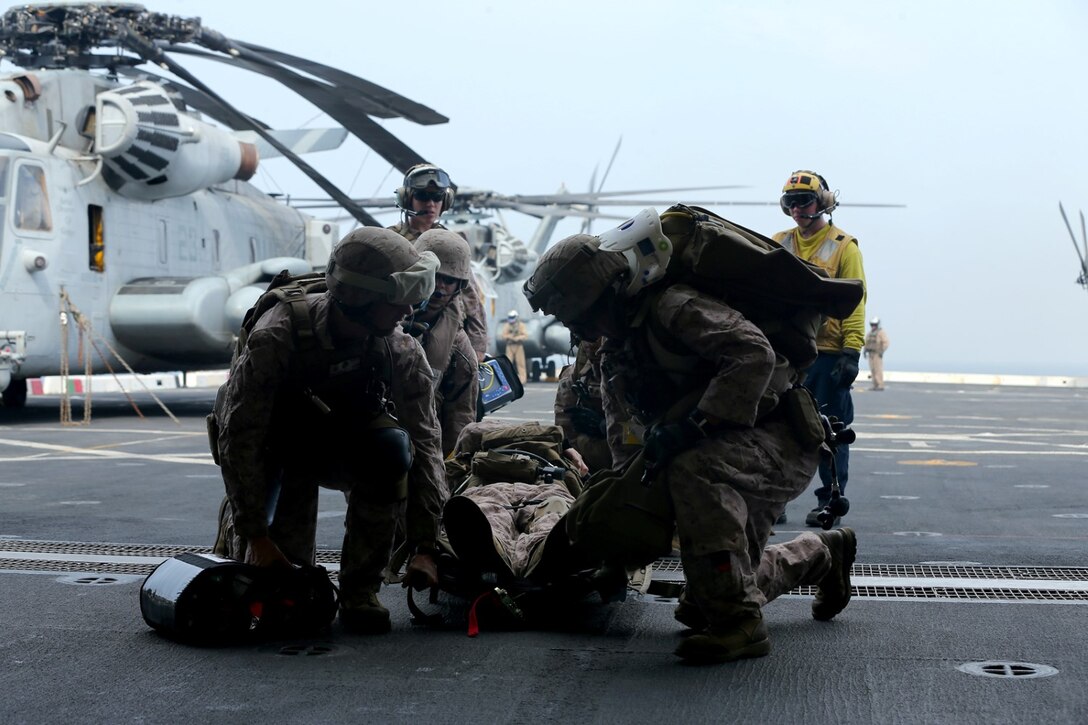 U.S. Navy hospital corpsmen with Combat Logistics Battalion 11, 11th Marine Expeditionary Unit (MEU), carry a simulated casualty to a CH-53E Super Stallion from Marine Medium Tiltrotor Squadron 163 (Reinforced), 11th MEU, as part of a mass casualty drill aboard the USS San Diego (LPD 22), Sept. 20. The 11th MEU is deployed with Makin Island Amphibious Ready Group as a theater reserve and crisis response force throughout U.S. Central Command and 5th Fleet area of responsibility. (U.S. Marine Corps photo by Cpl. Jonathan R. Waldman/Released)