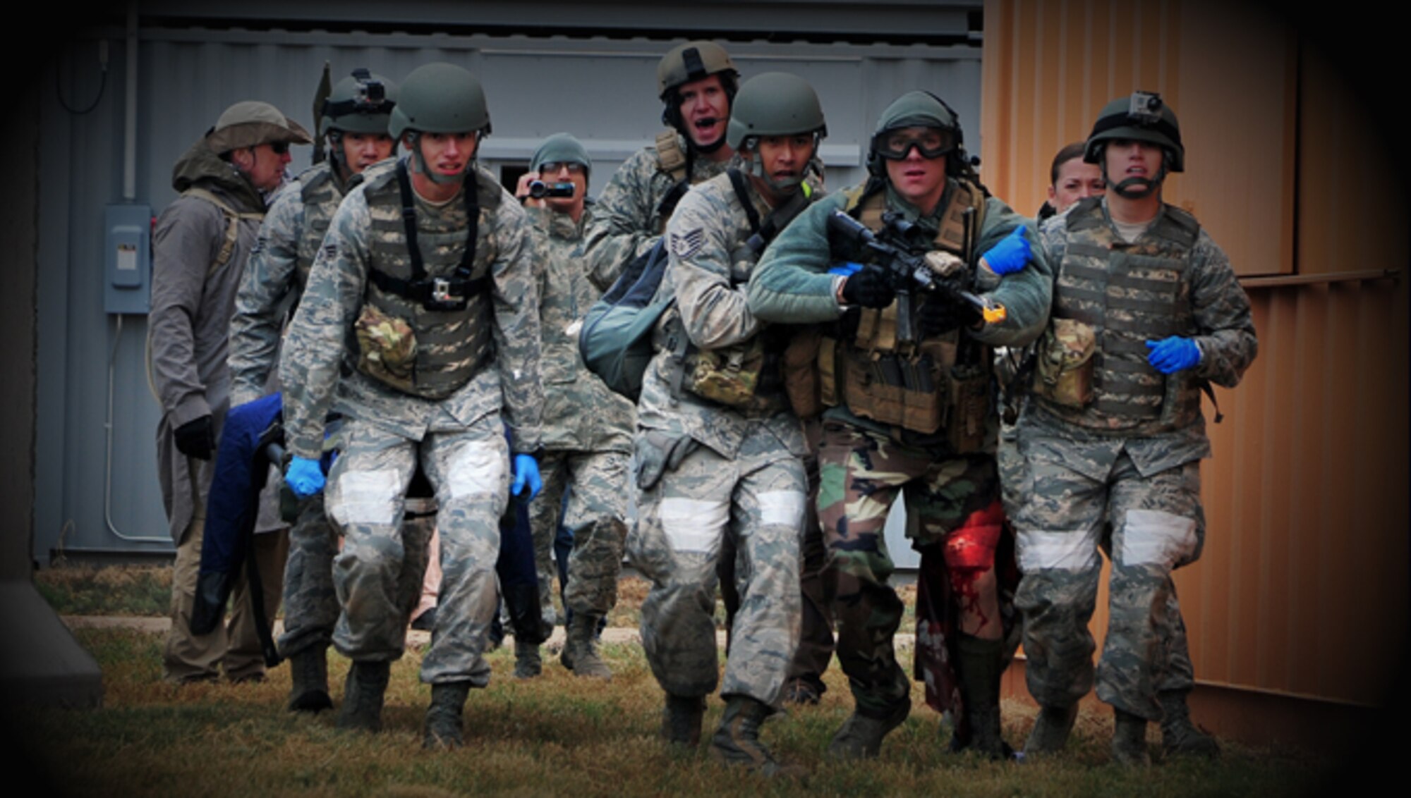 U.S. Air Force Emergency Medical Technicians carry a simulated injured individual on a litter and assist an airman suffering from a simulated gunshot wound to safety during the Commando Challenge Sept. 12, 2014 at Melrose Air Force Range, N.M. The challenge was the premier element of the EMT Rodeo, an intensive, two-day competition hosted by Cannon Air Force Base, N.M. (U.S. Air Force photo/Staff Sgt. Whitney Amstutz) 