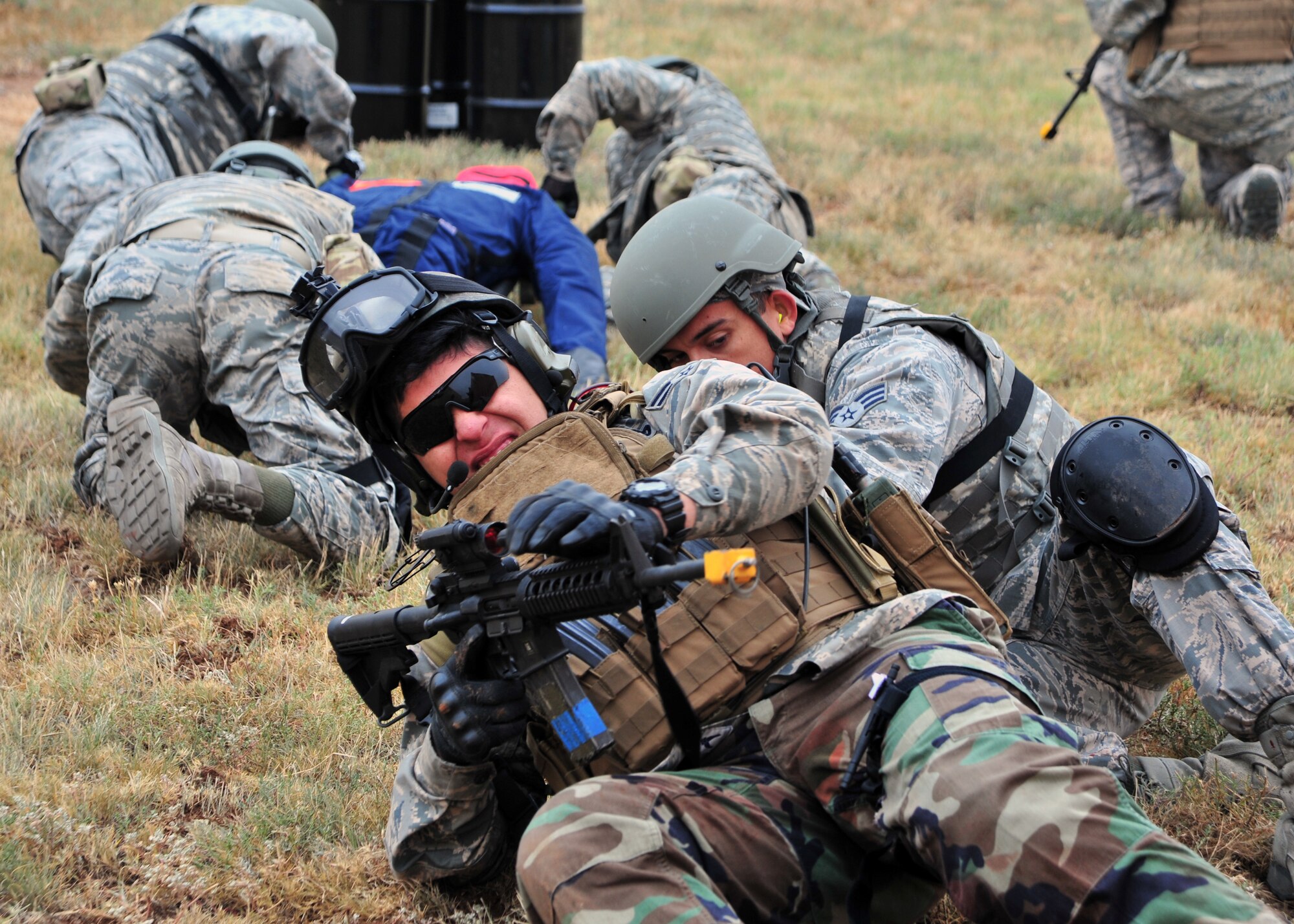 U.S. Air Force Emergency Medical Technicians crawl to cover during a simulated fire fight Sept. 12, 2014 at Melrose Air Force Range, N.M. The scenario, which was part of the Commando Challenge element of the EMT Rodeo, required participants to locate, treat and transport injured airmen in hostile conditions. (U.S. Air Force photo/Staff Sgt. Whitney Amstutz)