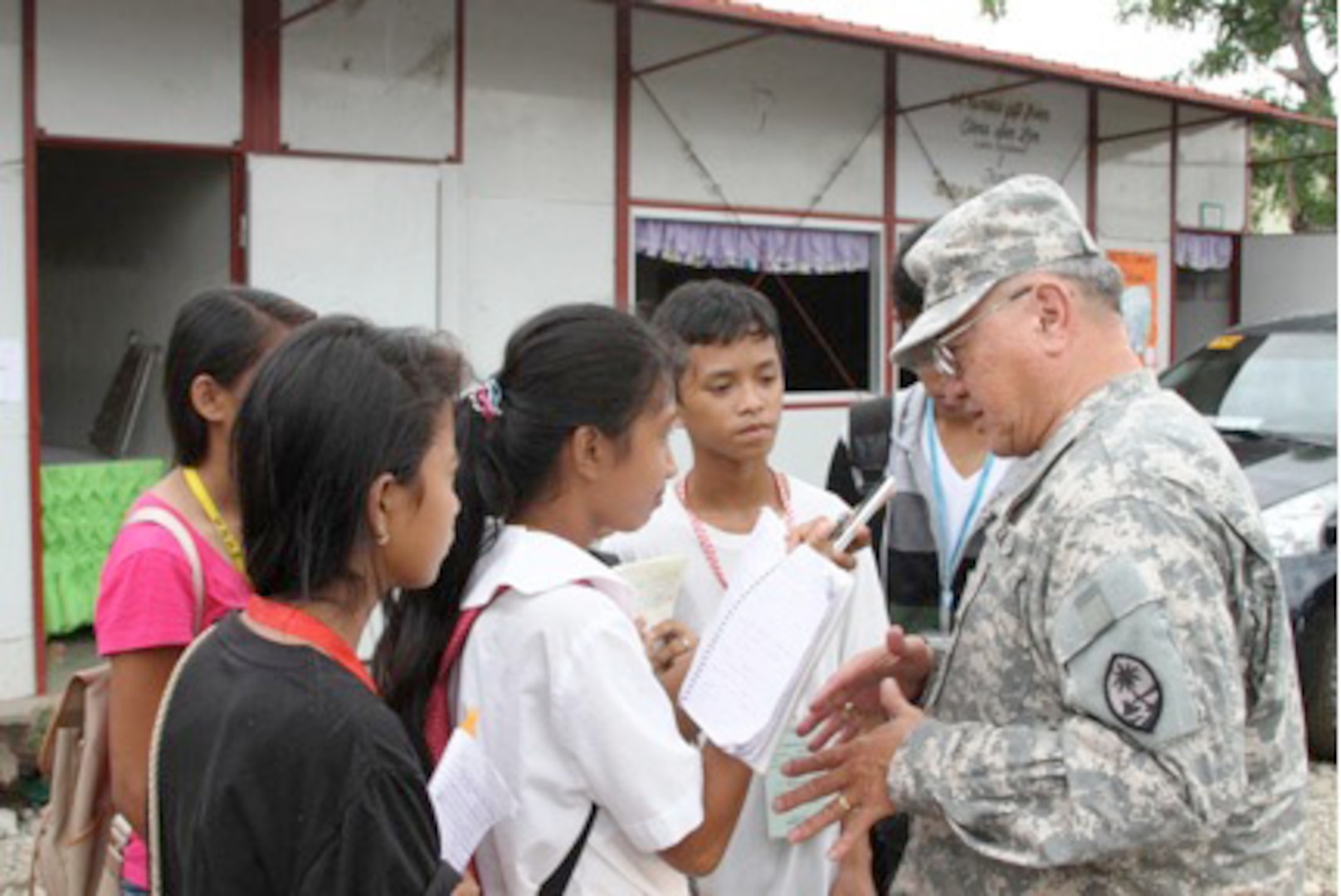 Maj. Gen. Benny M. Paulino is interviewed by students of Marasbaras National High School in Tacloban City, Philippines. Engineers from the Guam National Guard, the Hawaii National Guard and the Armed Forces of the Philippines rebuilt three buildings and seven classrooms, following the devastation of Typhoon Haiyan which swept through the Philippines last November.  