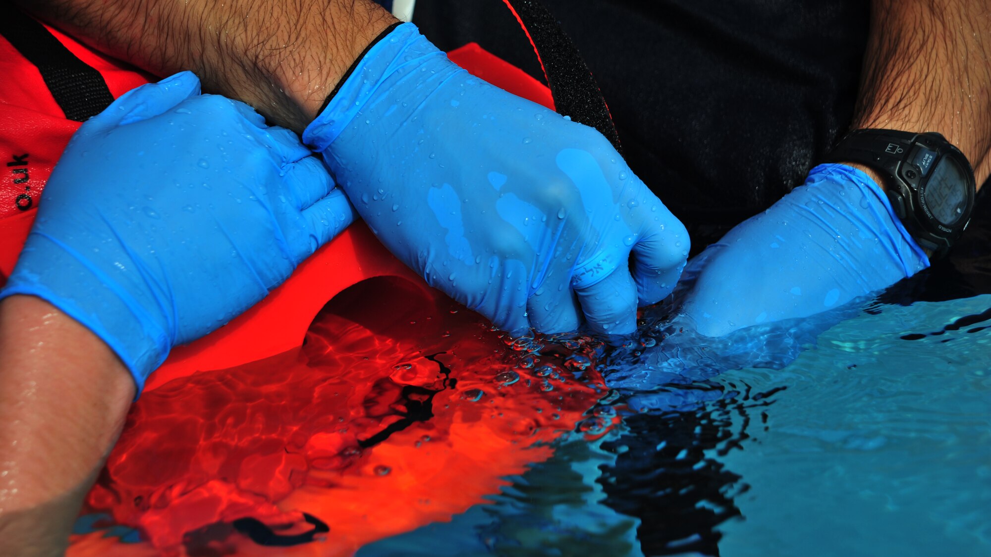 U.S. Air Force Emergency Medical Technicians stabilize the neck of a simulated drowning victim Sept. 13, 2014 at the swimming pool at Cannon Air Force Base, N.M. During the scenario, which was conducted as part of the EMT Rodeo, teams were required to save the victim from the water, restore breathing function, and report medical assessments to evaluators on scene. (U.S. Air Force photo/Staff Sgt. Whitney Amstutz)