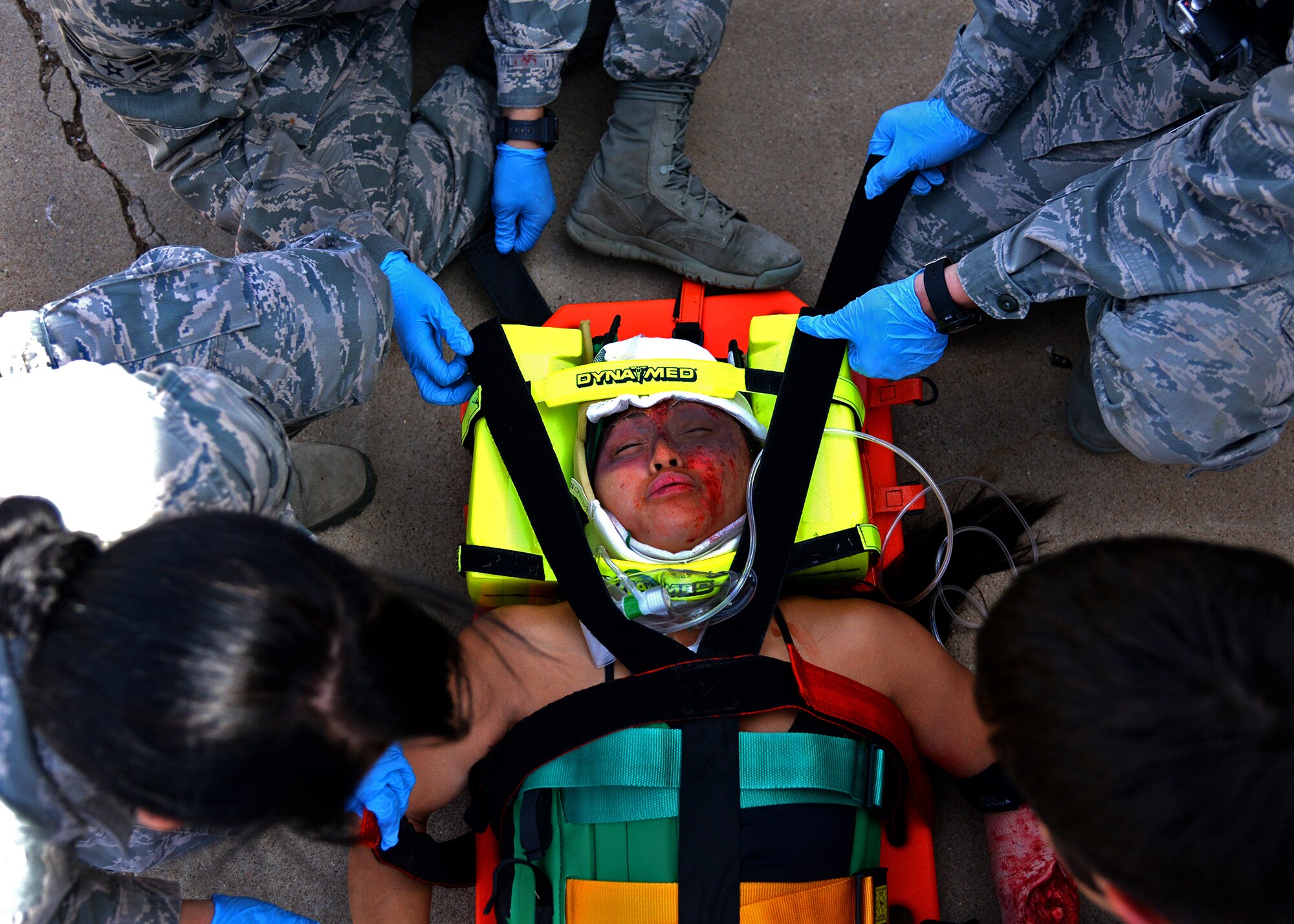 U.S. Air Force Emergency Medical Technicians support a victim’s neck on a stretcher Sept. 13, 2014 during the EMT Rodeo at Cannon Air Force Base, N.M. Members of the 27th Special Operations Medical Operations Squadron perfromed under extreme conditions, all while reassuring their patient actor that she was in good hands. (U.S. Air Force photo/Airman 1st Class Chip Slack)