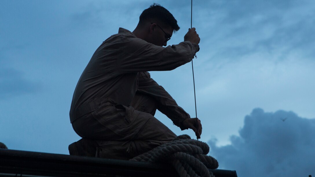 Cpl. Michael Elle, an assault amphibious vehicle crew chief with Alpha Company, 2nd Assault Amphibian Battalion, 2nd Marine Division, attaches an antenna to his AAV so he can communicate with the other AAVs in his platoon aboard Camp Lejeune, N.C., Sept. 8, 2014. Alpha Company Marines spent two days on Onslow Beach testing the seaworthiness of their AAVs before taking them out to sea to board the USS Whidbey Island in order to conduct ship operations.