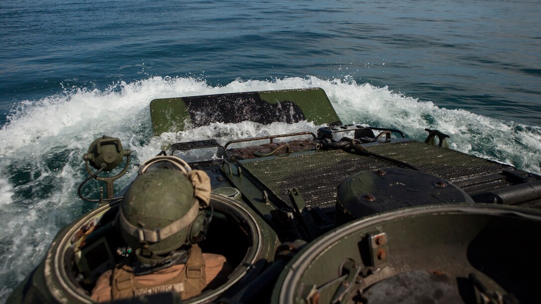 Pfc. Samuel J. Gennusa, an assault amphibious vehicle crewman, drives his AAV off of the USS Whidbey Island to conduct a Gator Square with other Marines in his platoon off the coast of Camp Lejeune, N.C., Sept. 10, 2014. A Gator Square is completed when the assault amphibious vehicles form a square out at sea and maneuver back onto the ship. Alpha Company Marines spent two days on Onslow Beach testing their AAVs before taking them out to sea to board the USS Whidbey Island in order to conduct the ship operations.  