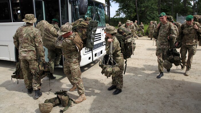 British soldiers of the 5, 6, and 7 Military Intelligence Battalions, 1 Intelligence Surveillance Reconnaissance Brigade, board buses to return to the barracks at the conclusion of Exercise Phoenix Odyssey on Sept. 17, 2014. The week-long field exercise, conducted alongside Marines of 2nd Intelligence Battalion, II Marine Expeditionary Force, provided scenario driven tests of their ability to integrate intelligence practices. The two forces have been training in a Military Operations in Urban Terrain facility on Camp Lejeune since the field portion began Sept 11, 2014.