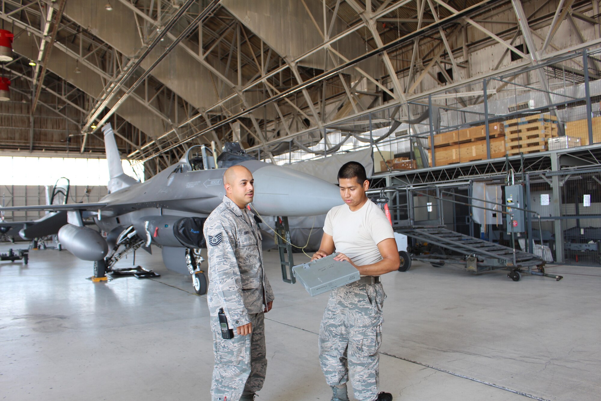 Tech. Sgt Uriel Cantu (left), F-16 flightline expediter, 412th AMXS, receives updates on the status of components removed from an F-16 from Staff Sgt Arturo Gomez, F-16 crew chief, in preparation of heavy maintenance on the fighter. (U.S. Air Force photo by Dawn Waldman)