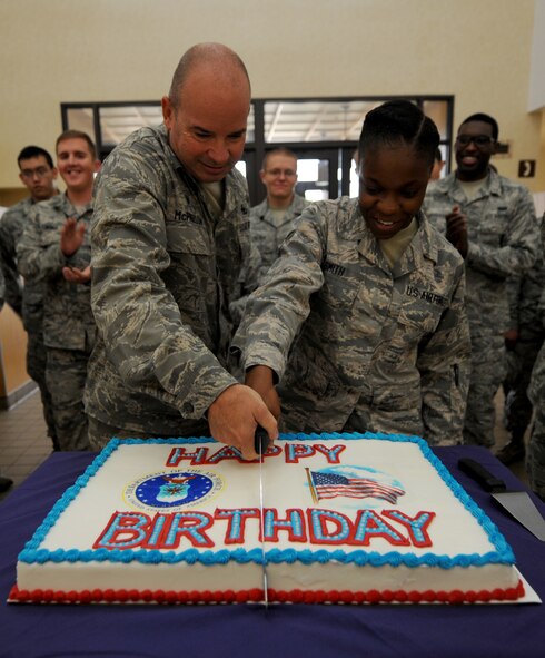 U.S. Air Force Lt. Col. Ray McPherson, 7th Logistical Readiness Squadron commander, and Airman 1st Class Kyrah Smith, 7th Medical Group, cut a cake together Sept. 18, 2014, at Dyess Air Force Base, Texas. As part of an Air Force tradition, the oldest and youngest Airmen on a base are the first to cut the Air Force birthday cake. (U.S. Air Force photo by Airman 1st Class Alexander Guerrero/Released)