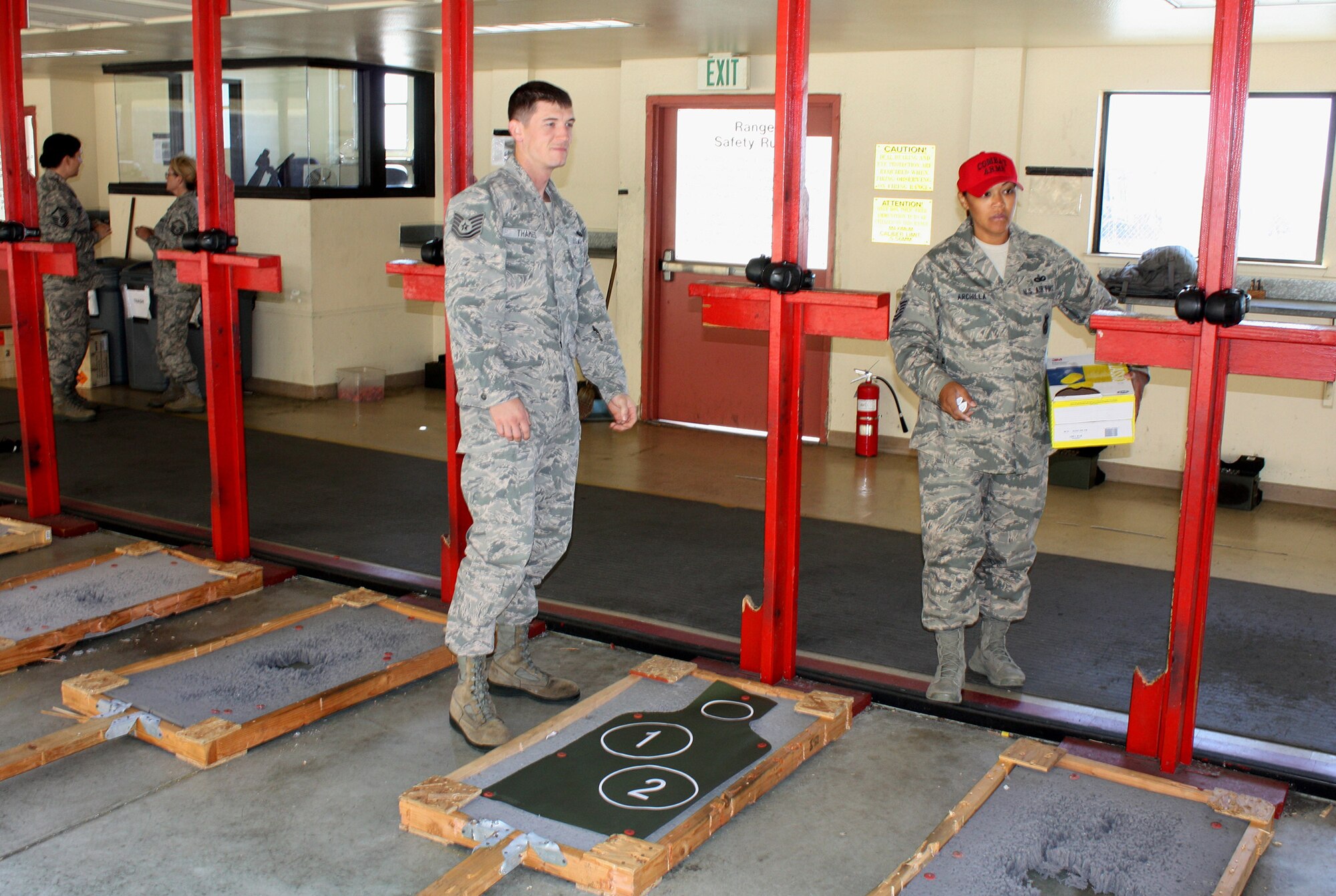 TRAVIS AIR FORCE BASE, Calif. -- Tech. Sgt. Rob Thames stands by his target as Tech. Sgt. Lan Archilla hands out extra hearing protection in preparation for firing on the Travis AFB CATM range. Thames, one of the  recruiting team for the 349th AMW, participated in a team building exercise, firing the M4 and M9 weapons during the squadron’s Fourth Quarter Operations and Training meeting. (U.S. Air Force photo/Senior Master Sgt. Alexander Brown)
