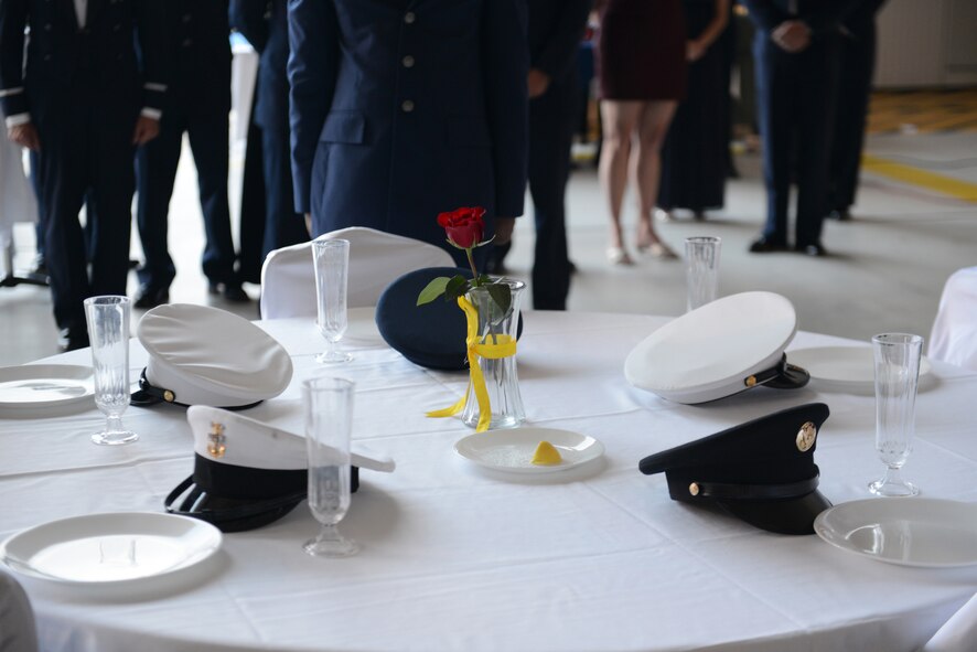 Covers representing each military branch of service sit on the POW/MIA table during the Air Force Ball Sept. 20, 2014, at Dyess Air Force Base, Texas. A table is traditionally set up at official military events and ceremonies to symbolize missing and fallen service members. (U.S. Air Force photo by Airman 1st Class Kedesha Pennant/Released)