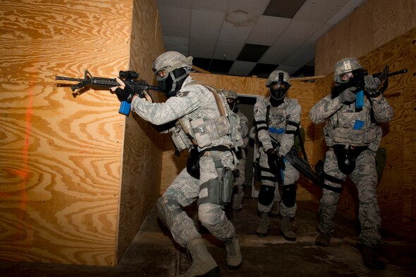 Members of the 5th Security Forces Squadron fan out after entering a room during a simulated full assault on Minot Air Force Base, N.D., Sept. 17, 2014. The team practiced locating a hidden individual in preparation for the 2014 Air Force Global Strike Challenge. (U.S. Air Force photo/Airman 1st Class Sahara L. Fales)