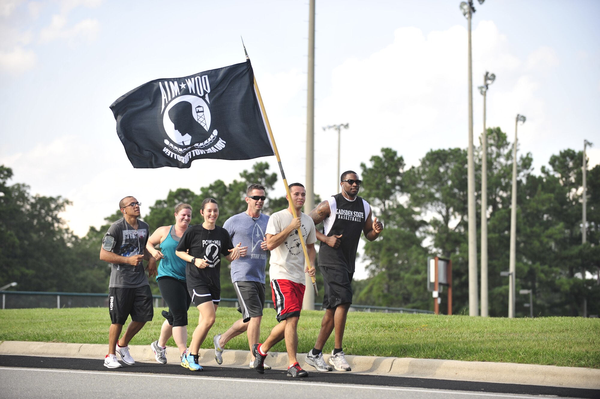 Members of Team Seymour carry the POW/MIA flag during the 24-hour POW/MIA Relay Run on Sept. 18, 2014, at Seymour Johnson Air Force Base, North Carolina. The relay came to a close as the Green Knights and the Guardian Brotherhood, both motorcycle groups who honor service members, first responders and members of the Department of Defense, escorted the POW/MIA flag bearers directly to the POW/MIA Ceremony at Heritage Park on Sept. 19, 2014. (U.S. Air Force photo/Airman 1st Class Shawna Keyes)