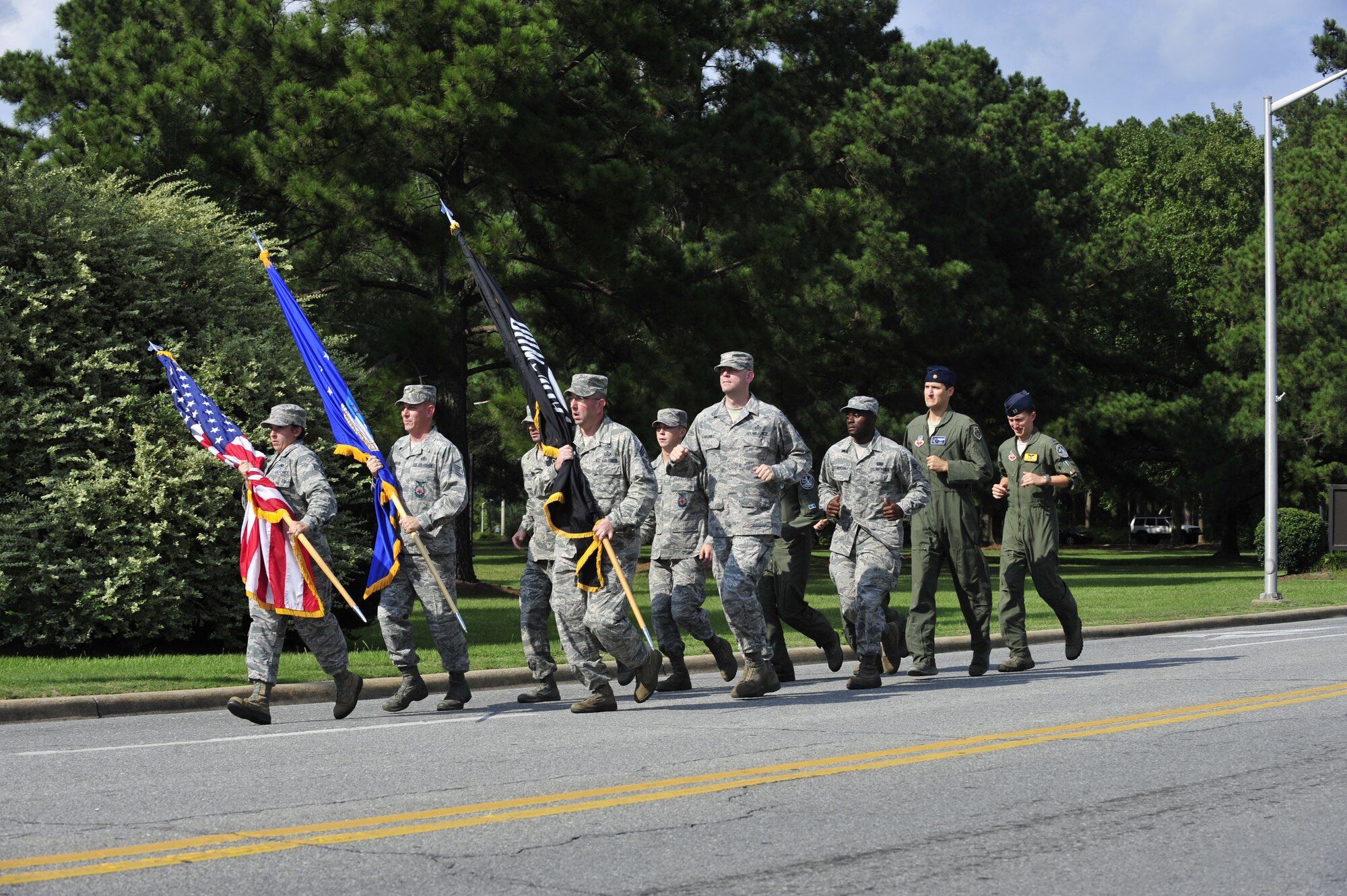 Chief Master Sgt. Jeffrey Craver, 4th Fighter Wing command chief, and Airmen assigned to the wing, carry the POW/MIA, Air Force and the American flags to the POW/MIA Ceremony on Sept. 19, 2014, at Seymour Johnson Air Force Base, North Carolina. The ceremony, held in conjunction with national POW/MIA Recognition Day, featured a missing-man formation flyover by four F-15E Strike Eagles assigned to the 4th FW, a reading of the Code of Conduct, a special presentation of the colors and remarks by both Col. Mark Slocum, 4th FW commander, and retired Army colonel and Medal of Honor recipient Walter J. Marm. (U.S. Air Force photo/Airman 1st Class Shawna Keyes)