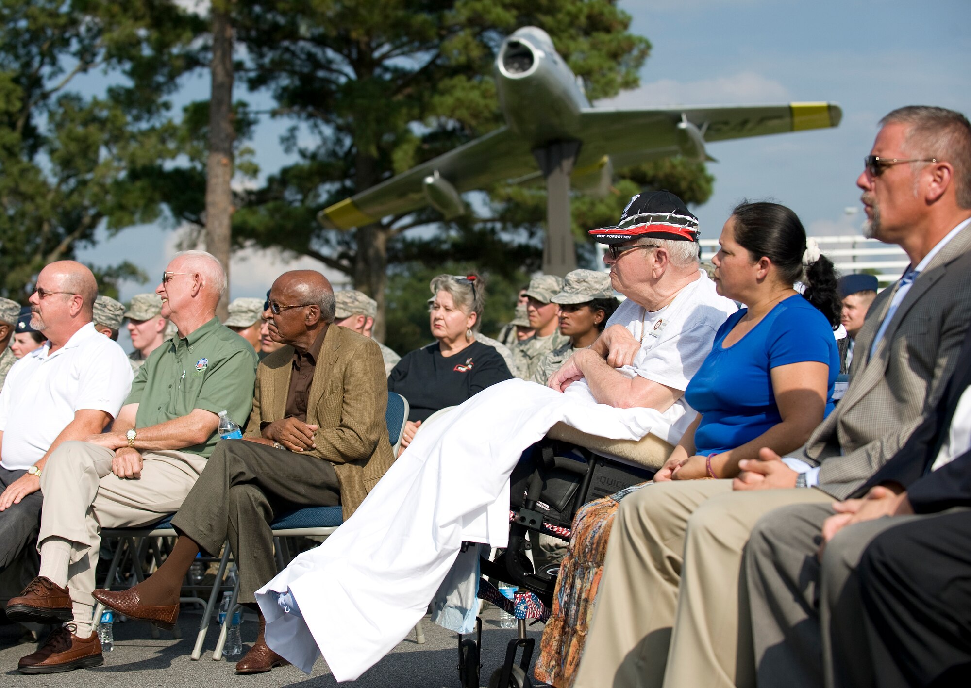 Gaspar Gonzalez (in white), an Army prisoner of war during the Korean War and recipient of the Purple Heart for injuries sustained in the Vietnam War, looks on during the POW/MIA Ceremony on Sept. 19, 2014, at Seymour Johnson Air Force Base, North Carolina. Gonzalez spent 22 days in captivity in a hut five miles from the Manchurian Border in 1950. (U.S. Air Force photo/Airman 1st Class Aaron Jenne)