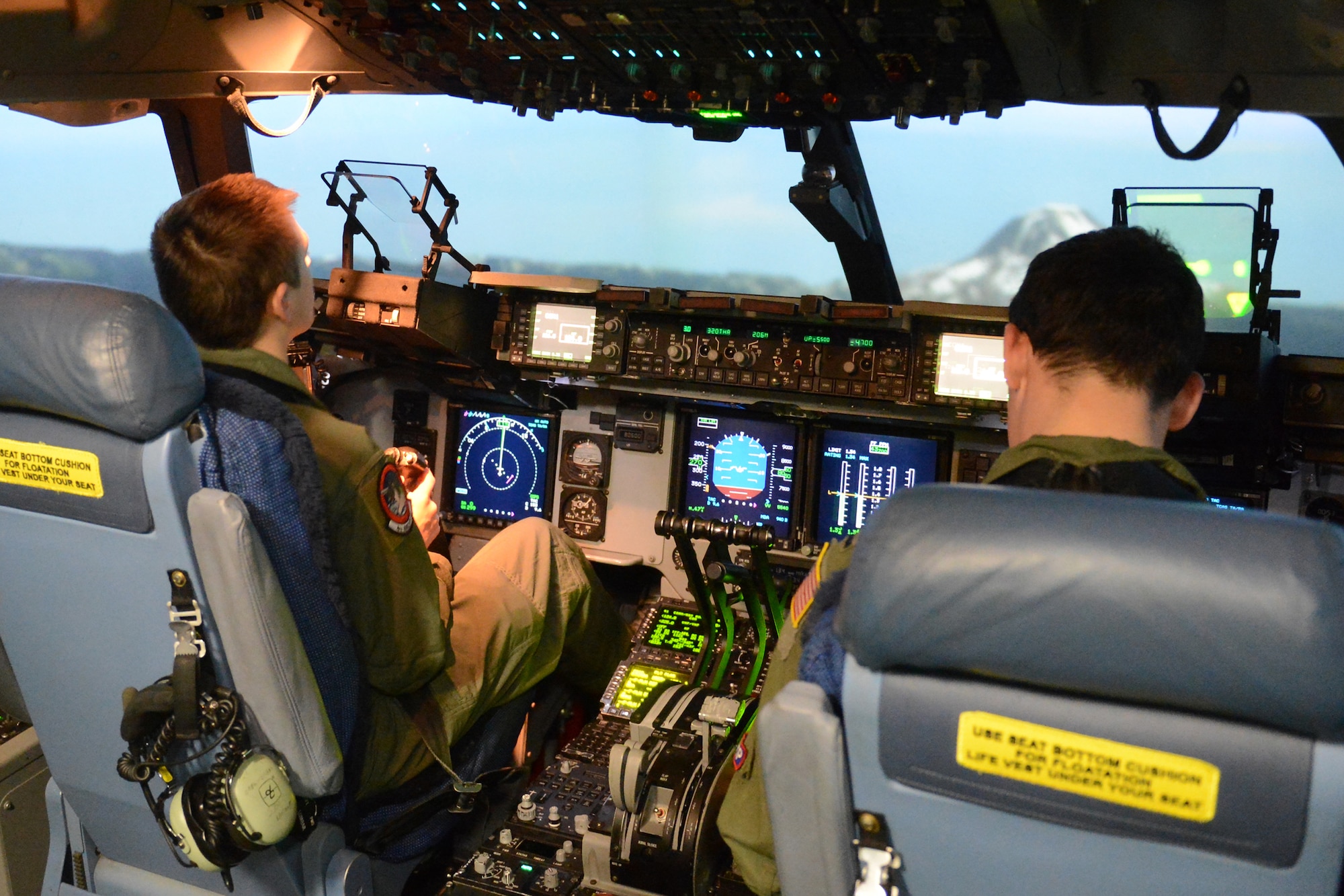 Will Krajewski (left), controls a C-17 Globemaster III in a simulator with 1st Lt. Christopher Lee, 4th Airlift Squadron pilot, Sept. 19, 2014, during his Pilot for a Day tour at Joint Base Lewis-McChord, Wash. With the help of Lee, Krajewski was able to simulate a take-off and perform simulated aerial maneuvers such as a barrel roll, stalls, and sharp climbs.  (U.S. Air Force photo/Airman 1st Class Keoni Chavarria)