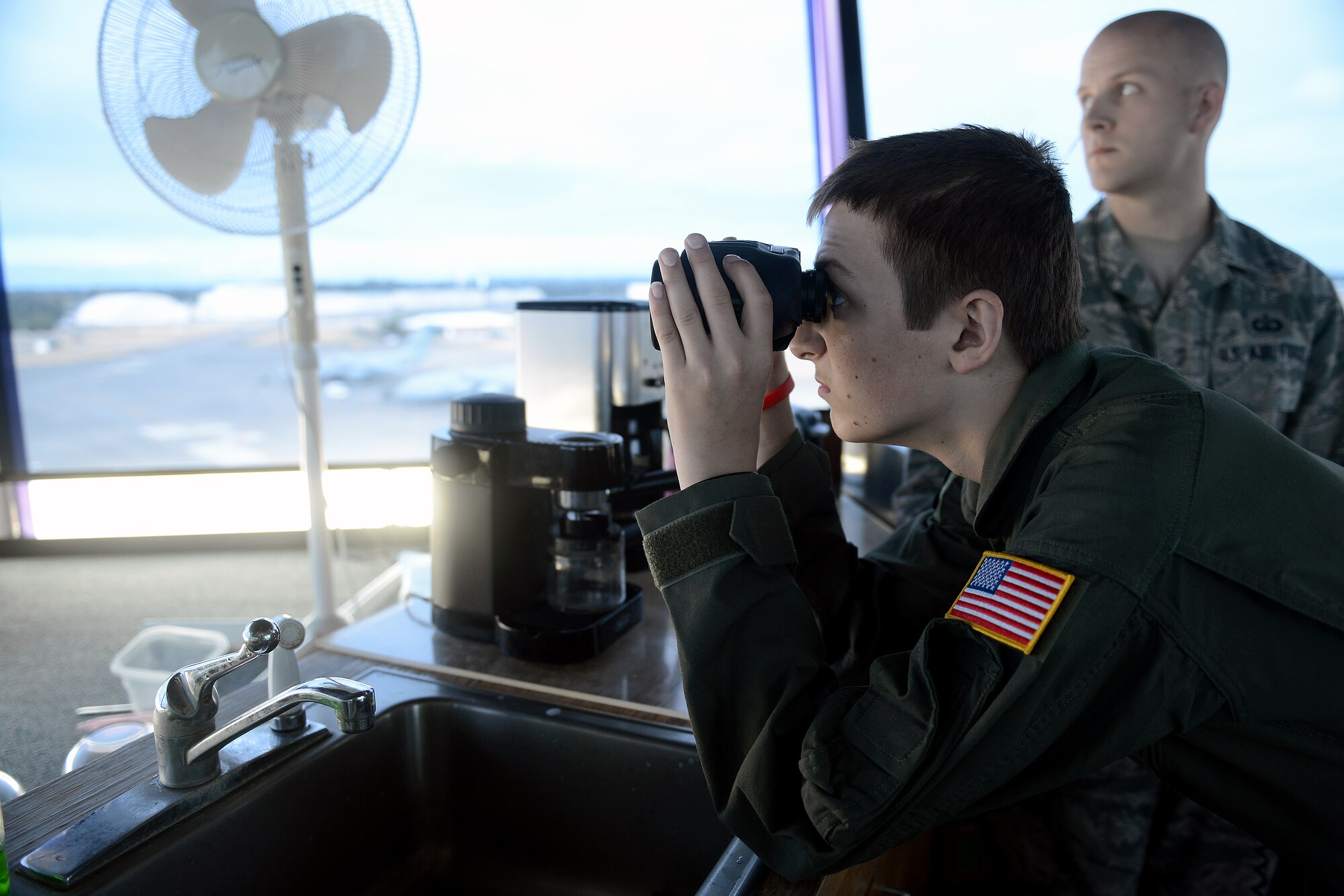 Will Krajeski, looks through a pair of binoculars, Sept. 19, 2014, from the control tower during his Pilot for a Day tour at Joint Base Lewis-McChord, Wash. While at the control tower, Krajewski was awarded by the 62nd Operations Support Squadron, a functional badge for an air traffic controller. (U.S. Air Force photo/Airman 1st Class Keoni Chavarria)