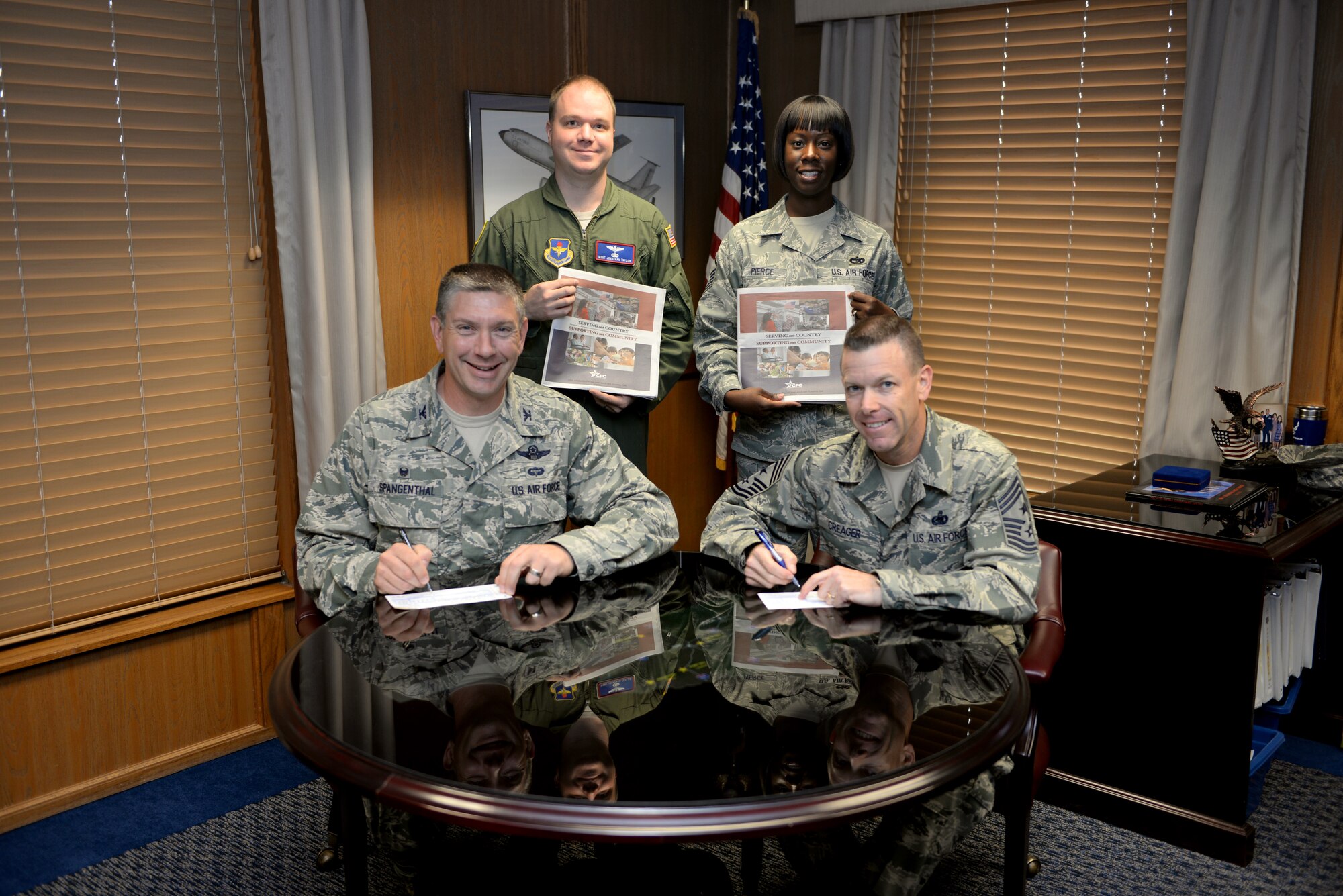 ALTUS AIR FORCE BASE, Okla. -- U.S. Air Force Col. Bill Spangenthall, 97th Air Mobility Wing commander; Chief Master Sgt. Bryan Creager, 97th AMW command chief; Master Sgt. Jonathon Taylor, 54th Air Refueling Squadron first sergeant and Master Sgt. Shantay Pierce, 97th Logistics Readiness Squadron traffic management superintendent, pose for a photo during the 2014 Combined Federal Campaign pledge signing, Sept. 22, 2014. Through the CFC, federal employees have donated more than $7 billion to a diversity of people and causes in great need. Last year, Altus AFB raised approximately $93,500 for charities around the world and has set a goal of approximately $90,000 for this year. The campaign will run Oct. 1-Nov. 14 and is intended to promote and support voluntary, cost-efficient and effective philanthropy amongst federal employees. (U.S. Air Force photo by Airman 1st Class Megan E. Acs/Released)