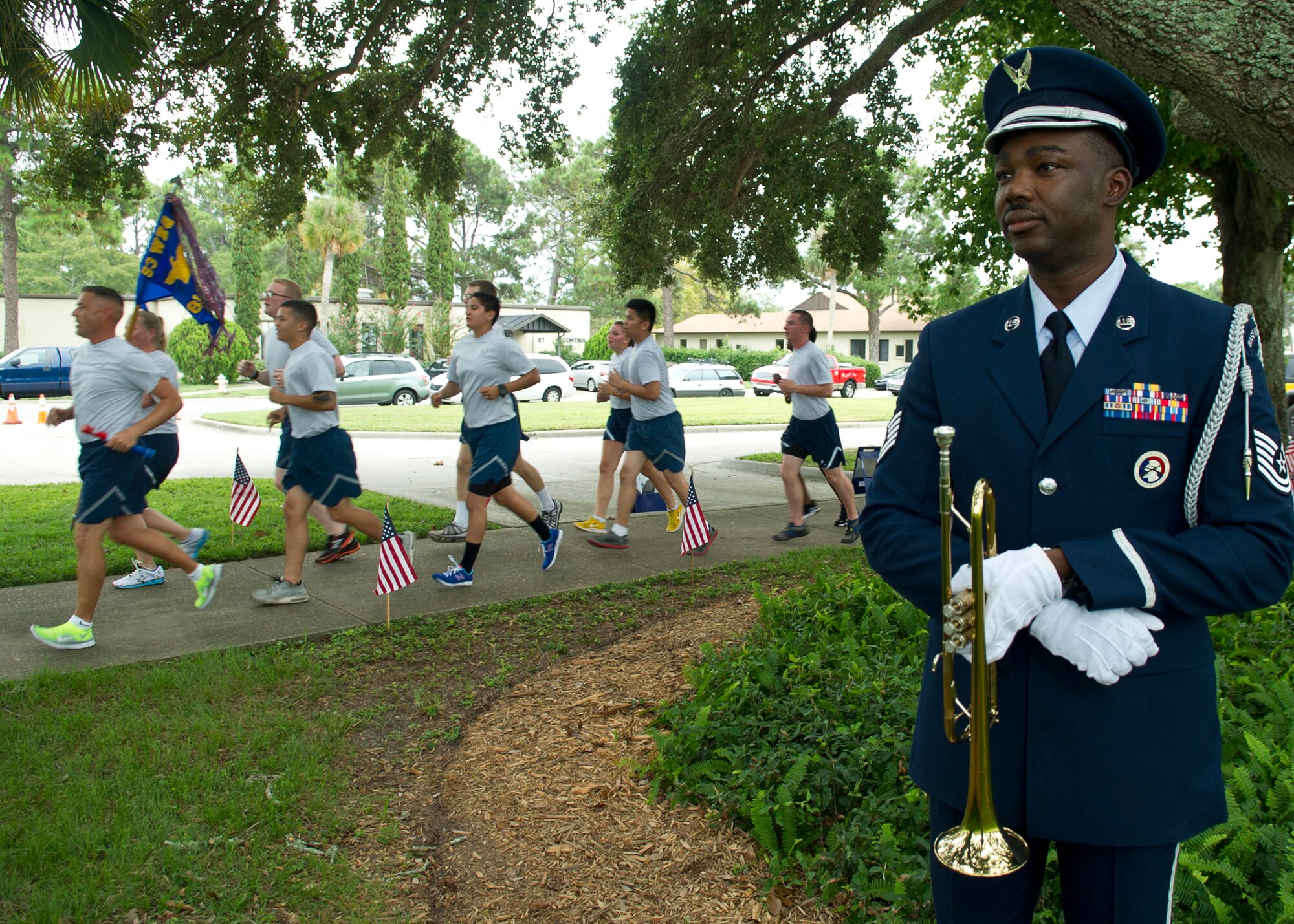 Tech. Sgt. Calvin Charles, 325 Civil Engineer Squadron dorm superintendent, poses as Airmen pass by during the 24-hour POW/MIA vigil run Sept 19 at Flag Park. The POW/MIA ceremony is performed in recognition to service-members who are prisoners of war or missing in action. (U.S. Air Force photo/Airman 1st Class Ty-Rico Lea)