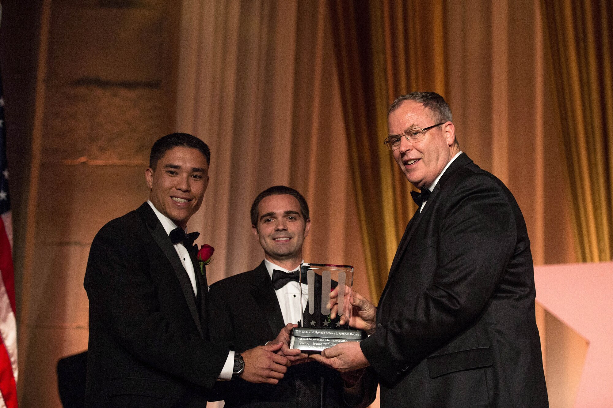 Deputy Defense Secretary Bob Work, right, presents the 2014 Samuel J. Heyman Service to America Medals to Ben Tran, left, and Sean Young, center, for their work in the field of national security and international affairs at the Sammie Awards national gala in Washington, D.C., Sept. 22, 2014.  (DoD photo by U.S. Navy Petty Officer 2nd Class Sean Hurt) 
