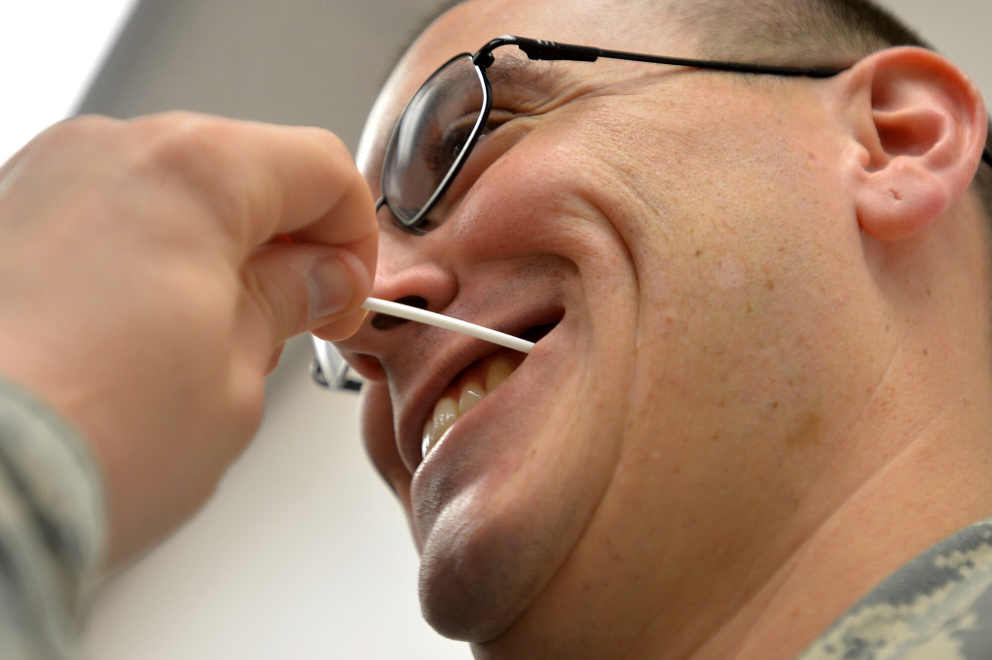 U.S. Air Force Airman 1st Class Jonathan Bass, 20th Fighter Wing public affairs photojournalist, swabs his mouth during the process of registering to be a bone marrow donor at Shaw Air Force Base, S.C., Sept. 19, 2014. The Department of Defense C.W. Bill Young Bone Marrow Program is always in need of potential bone marrow donors. (U.S. Air Force photo by Staff Sgt. Kenny Holston/Released)