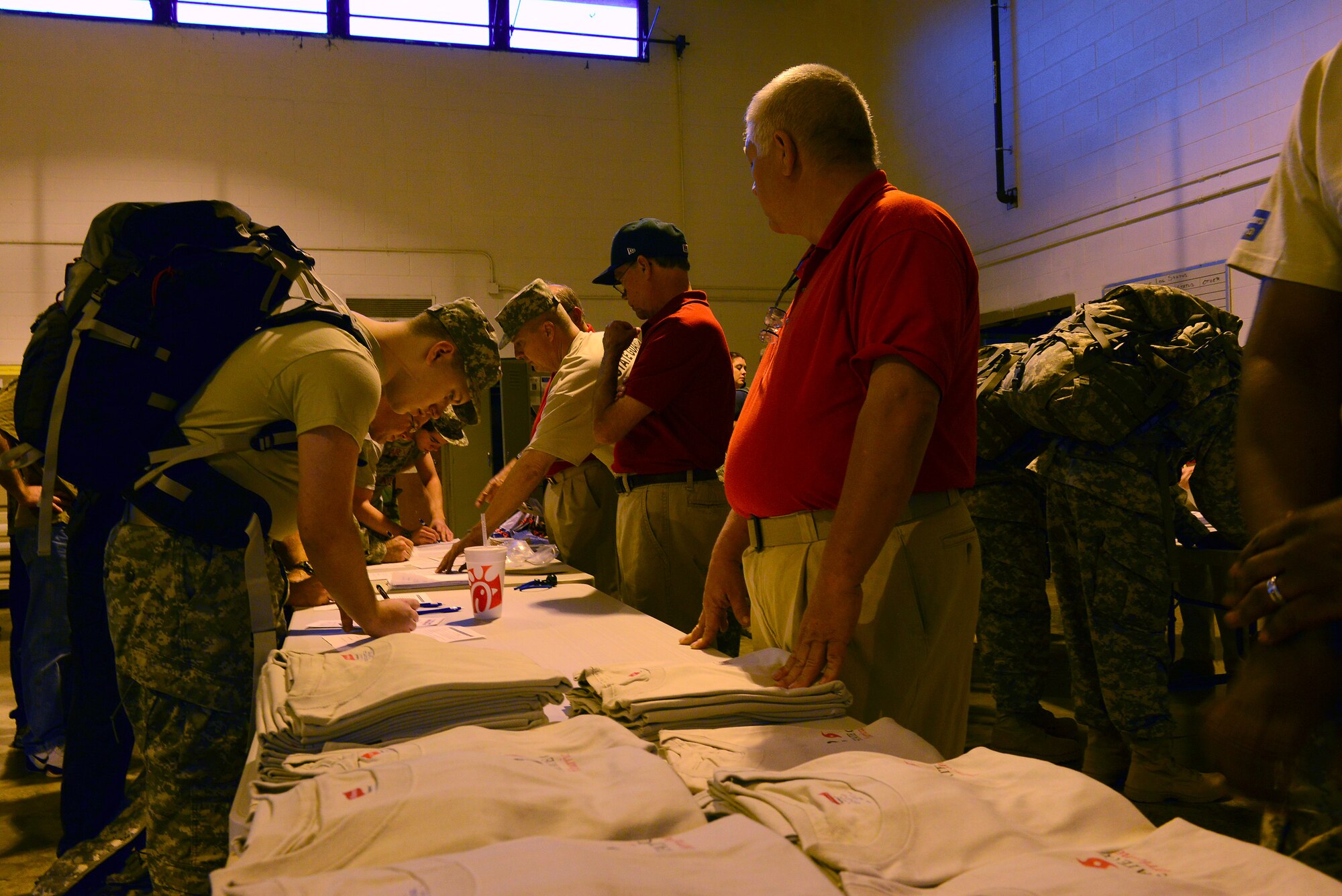 Hurricane Hike participants sign-in to receive a number and event T-shirt at the Camden National Guard Armory, Camden, S.C., Sept. 20, 2014. Each participant hiked the 10K route with a 45-pound pack. Those who finished the course received an event challenge coin and a certificate. (U.S. Air Force photo by Airman 1st Class Diana M. Cossaboom/Released)
